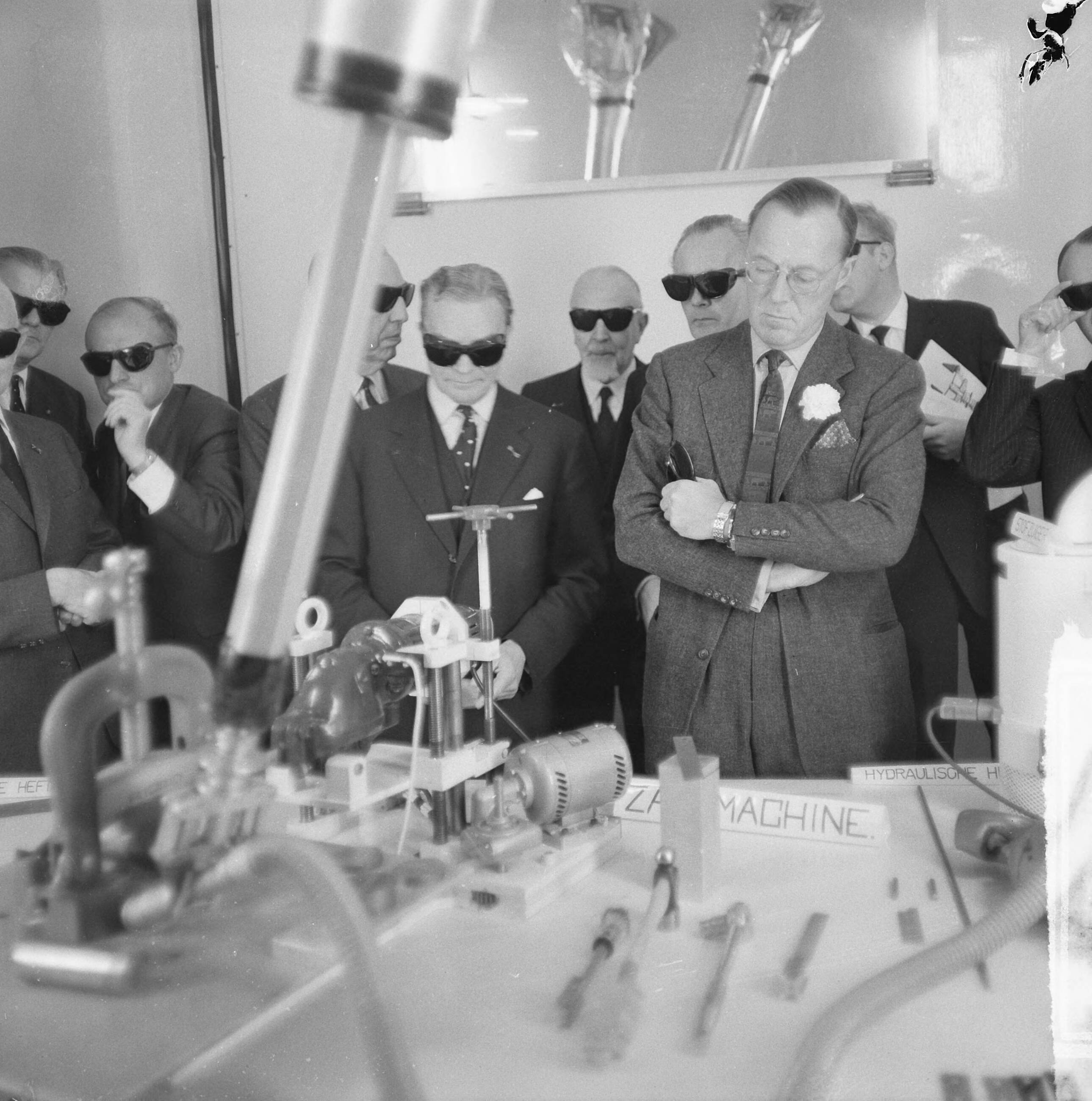 Fotocollectie Anefo — Prins Bernhard bezocht reactorcentrum Petten, de prins (zonder zwarte bril) kijkt naar machines die op afstand bediend worden — Foto: Nijs, Jac. de / Anefo. Licentie: Set B: Rechtenvrij / Publiek Domein. Bron: Nationaal Archief. http://hdl.handle.net/10648/aa8600a8-d0b4-102d-bcf8-003048976d84