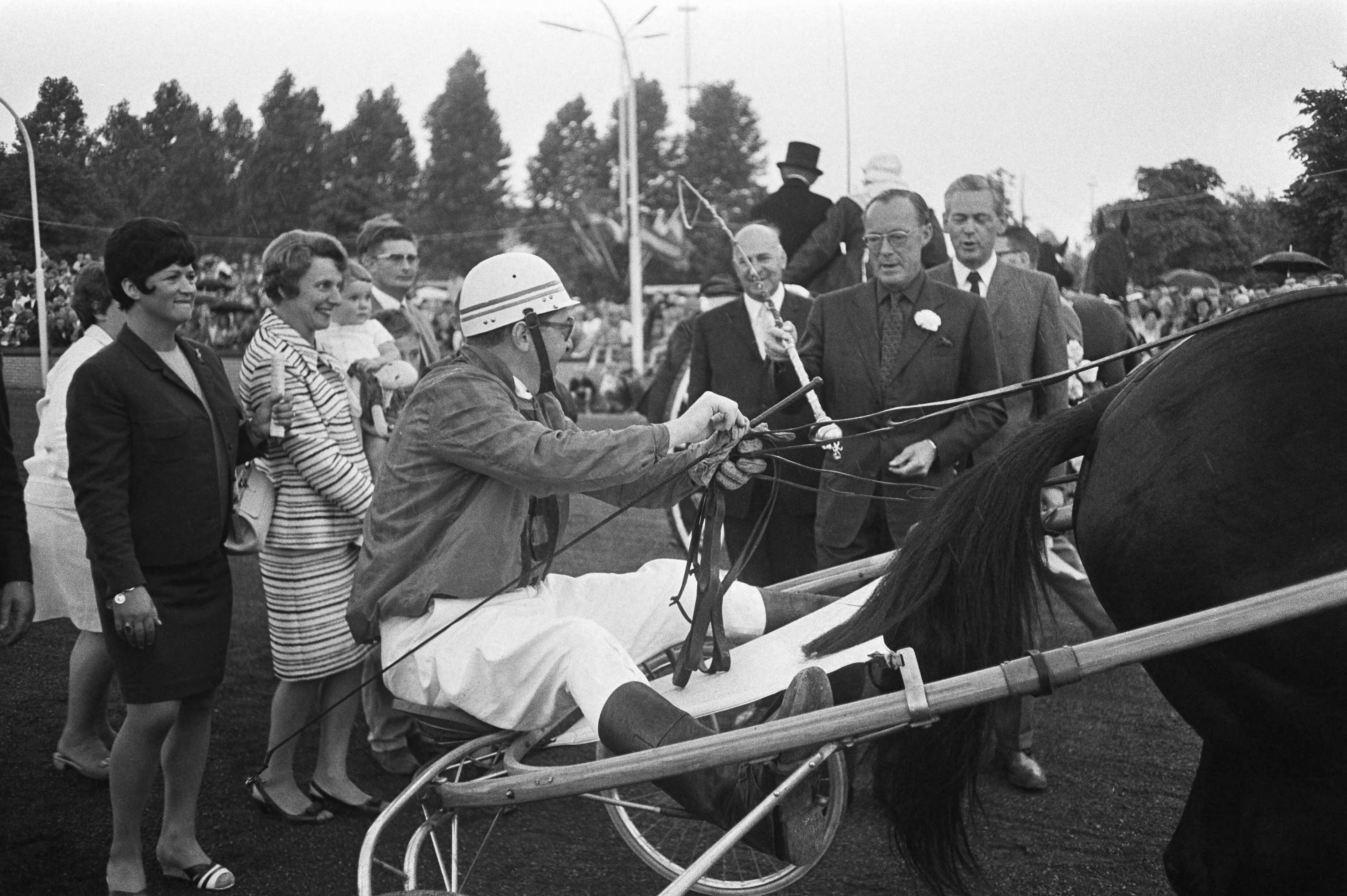 Draverijen om de Gouden Zweep te Hilversum — Prins Bernhard geeft pikeur J. V. Dooyeweerd de Gouden Zweep — Foto: Fotograaf Onbekend / Anefo. Licentie: Set B: Rechtenvrij / Publiek Domein. Bron: Nationaal Archief. http://hdl.handle.net/10648/ab71a314-d0b4-102d-bcf8-003048976d84