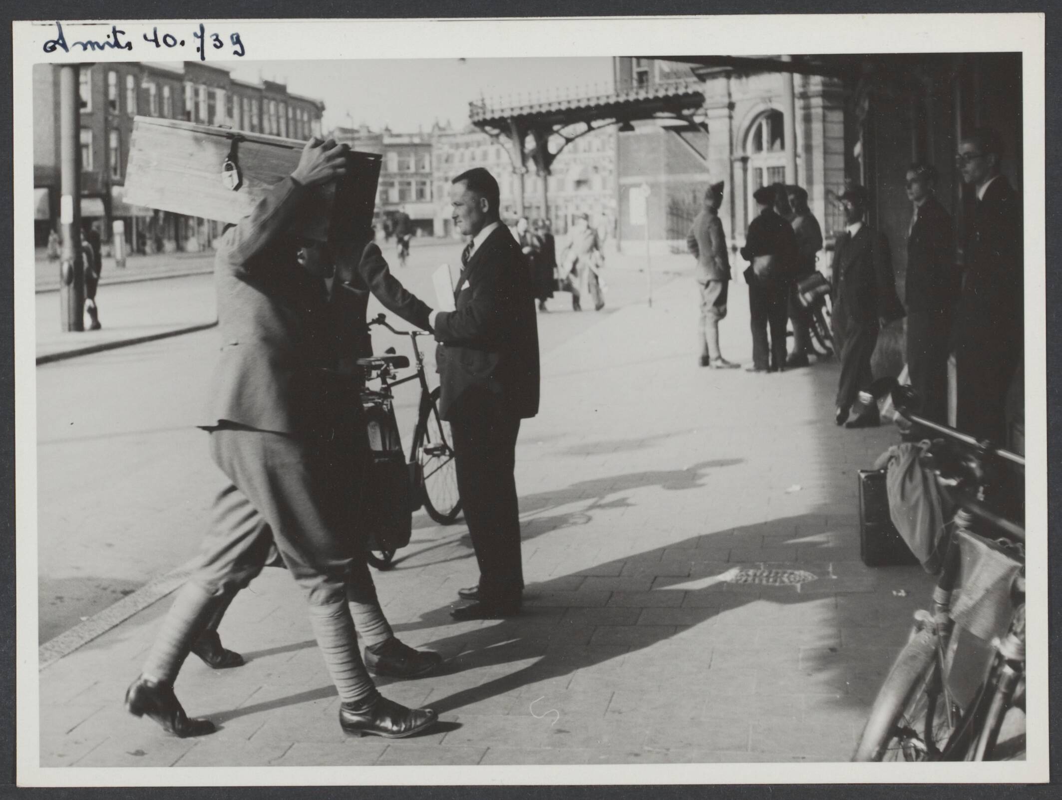 Demobilisatie 1940 — Serie: Demobilisatie Den Haag [Een militair met een kist op de schouder bij Station Hollands Spoor] — Foto: Smits, Roeland Pieter / Spaarnestad. Licentie: Set B: Rechtenvrij / Publiek Domein. Bron: Nationaal Archief. http://hdl.handle.net/10648/ff9e3f12-2fe9-889a-748e-2814a8d751fc