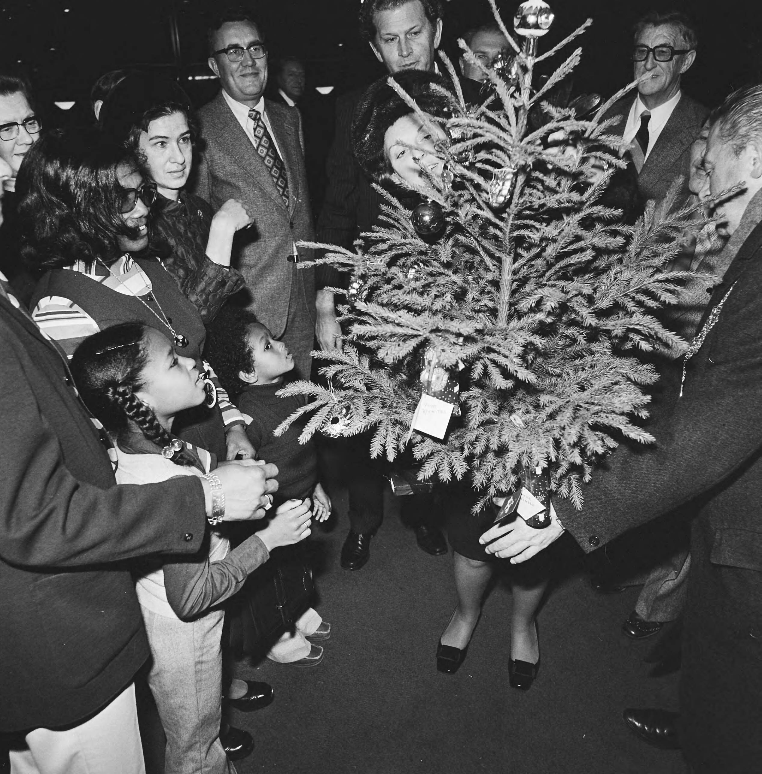 Prinses Beatrix overhandigt de sleutel van de dertigste burgerzinwoning in het stadhuis van Den Haag — De prinses met kinderen en genodigden bij een kerstboom — Foto: Mieremet, Rob / Anefo. Licentie: Set B: Rechtenvrij / Publiek Domein. Bron: Nationaal Archief. http://hdl.handle.net/10648/ac3edab4-d0b4-102d-bcf8-003048976d84