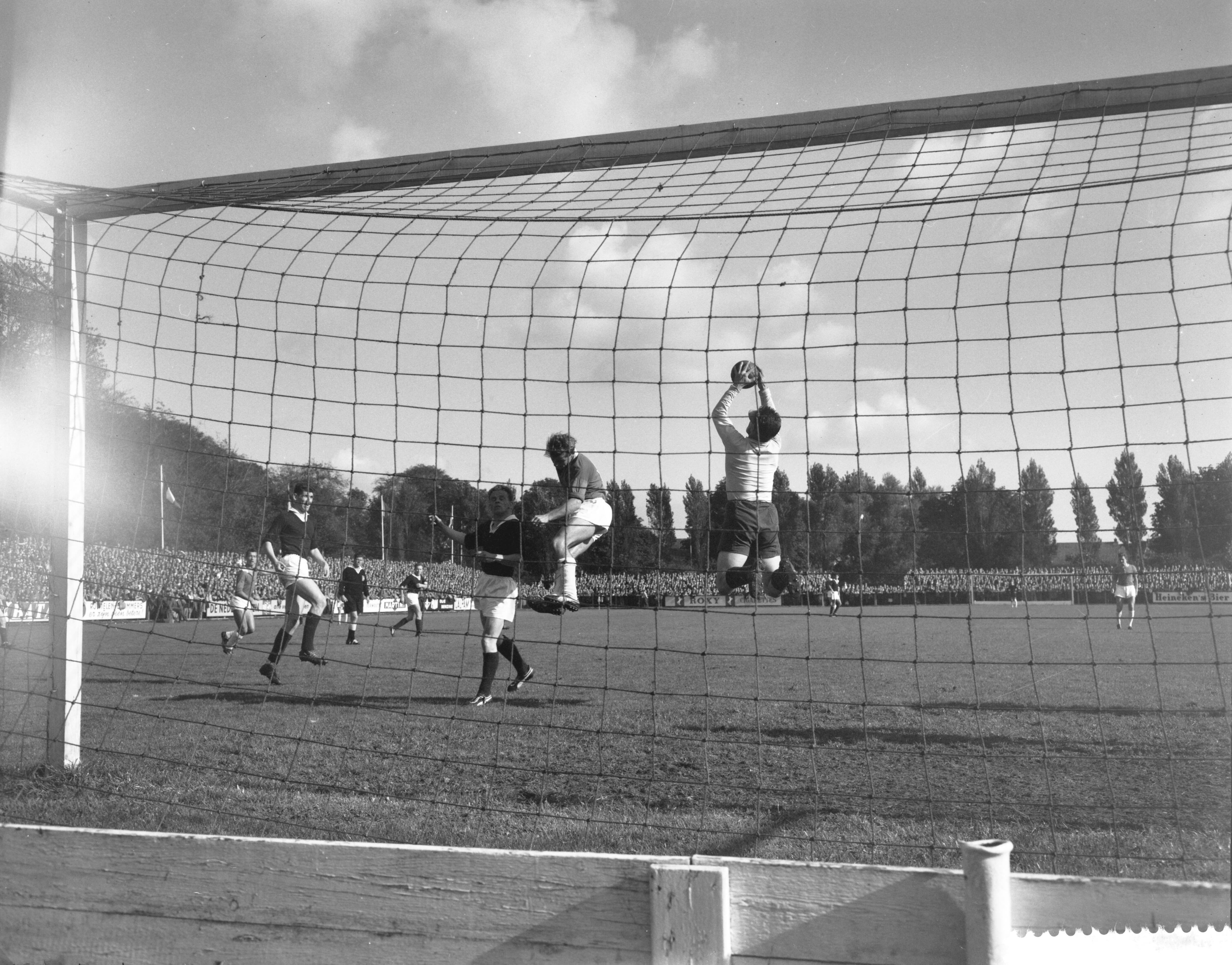 Fotocollectie Anefo — Voetbal. Alkmaar'54 tegen Rapid JC 1-1. Spelmoment, keeper Jacobs van Rapid JC pakt de bal met een sprong — Foto: Lindeboom, Henk / Anefo. Licentie: Set B: Rechtenvrij / Publiek Domein. Bron: Nationaal Archief. http://hdl.handle.net/10648/a9ba4ee0-d0b4-102d-bcf8-003048976d84