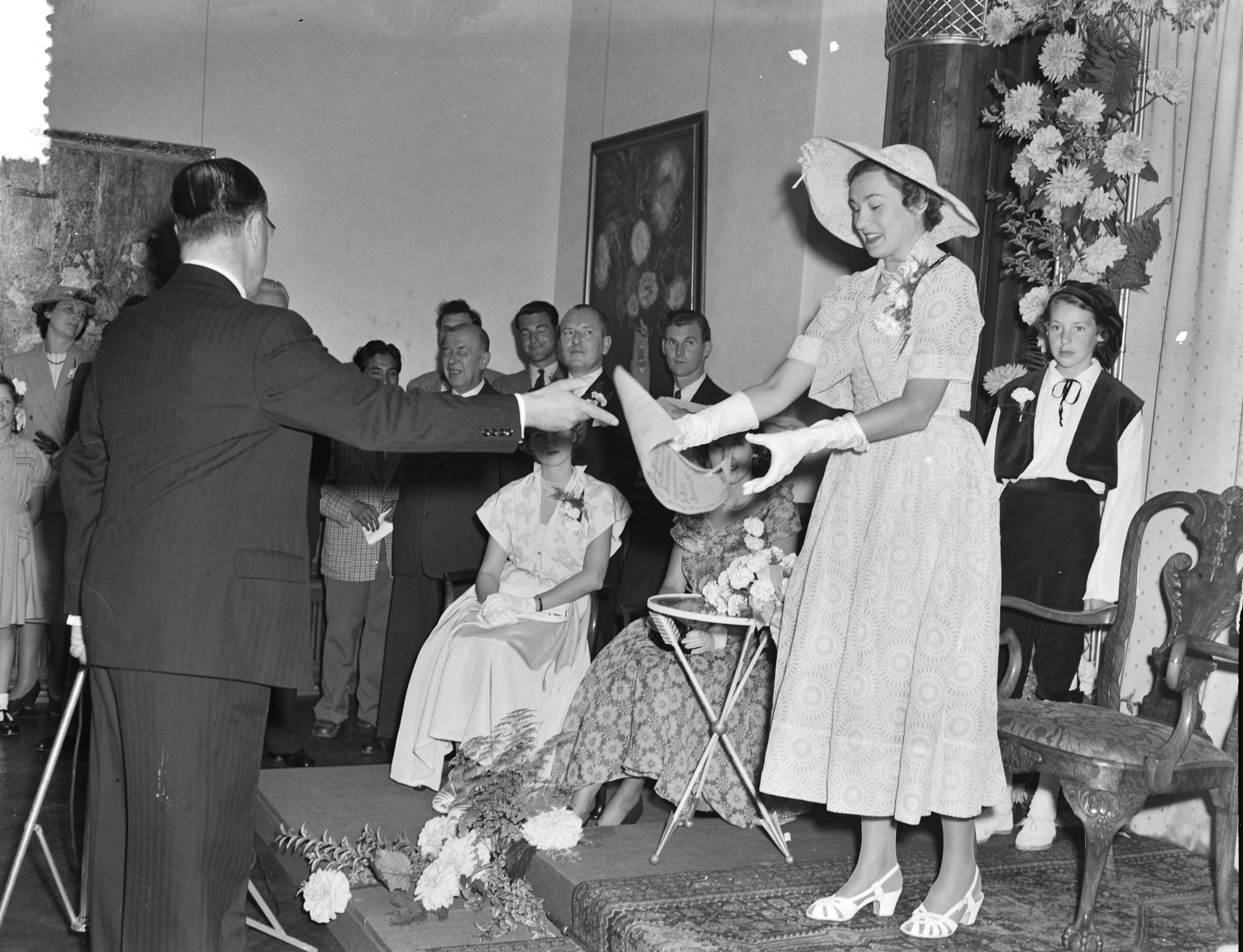 Intocht Bloemenkoningin van Den Haag — Intocht Bloemenkoningin van Den Haag. Zij ontvangt een oorkonde van burgemeester F.M.A. Schokking — Foto: Pot, Harry / Anefo. Licentie: Set B: Rechtenvrij / Publiek Domein. Bron: Nationaal Archief. http://hdl.handle.net/10648/a8edcd16-d0b4-102d-bcf8-003048976d84