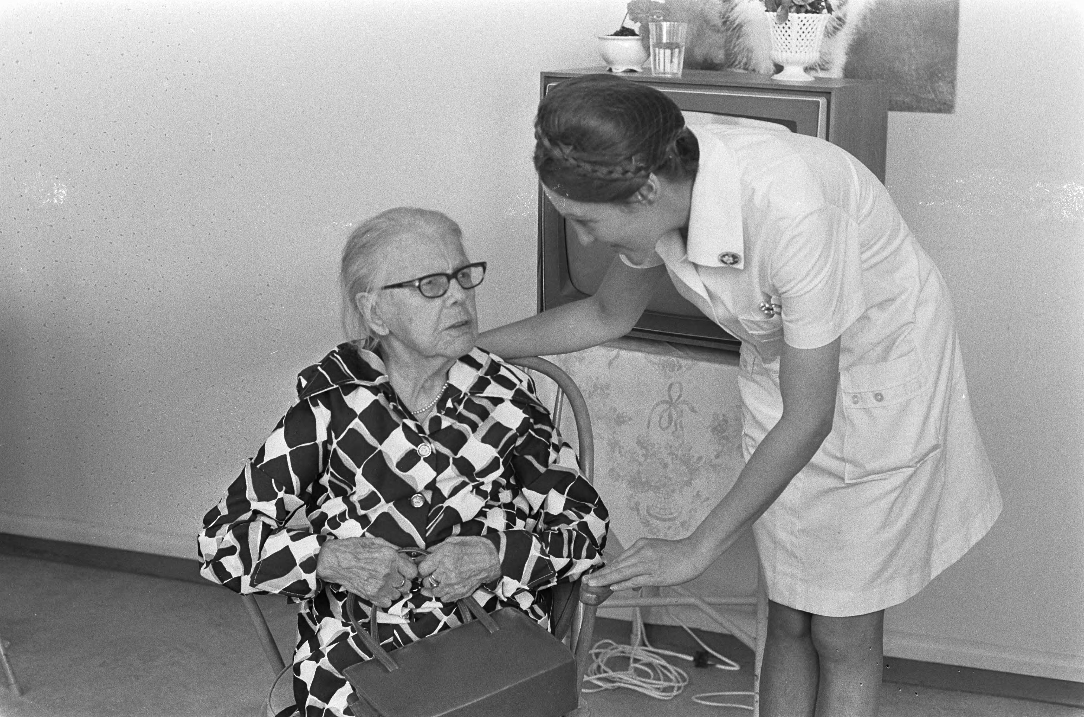 Fotocollectie Anefo — 105-jarige in Den Haag ; mevrouw M. J. van de Berge Stroomsnijders die op 10 oktober aanstaande 105 jaar wordt met verpleegster / — Foto: Peters, Hans / Anefo. Licentie: Set B: Rechtenvrij / Publiek Domein. Bron: Nationaal Archief. http://hdl.handle.net/10648/ac56ff68-d0b4-102d-bcf8-003048976d84