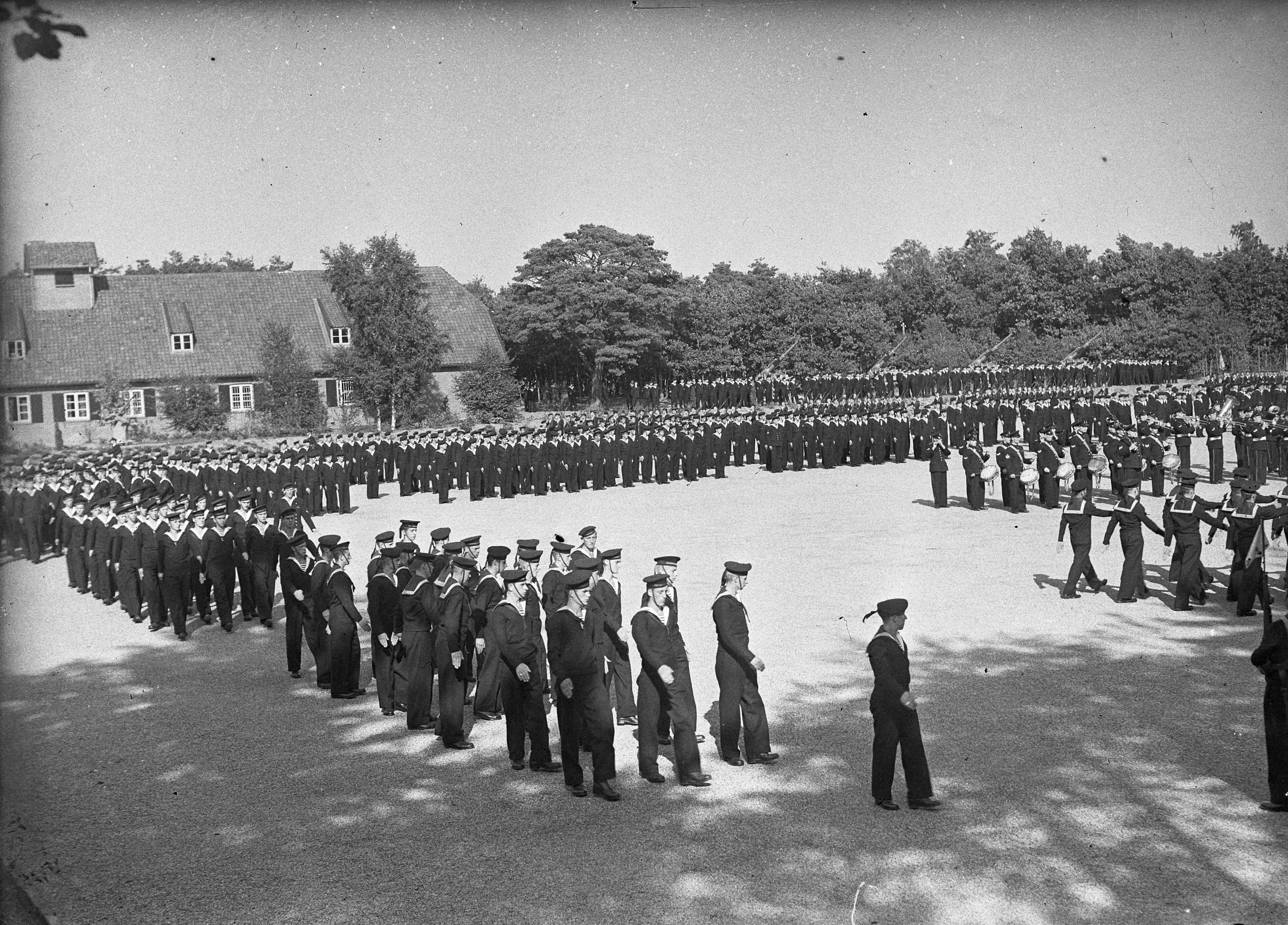 Fotocollectie Anefo — Beëdiging van 29 marine-officieren op het Marine Opleidingskamp te Hilversum. Defilé — Foto: Sagers, Harry / Anefo. Licentie: Set B: Rechtenvrij / Publiek Domein. Bron: Nationaal Archief. http://hdl.handle.net/10648/ad74f288-d0b4-102d-bcf8-003048976d84