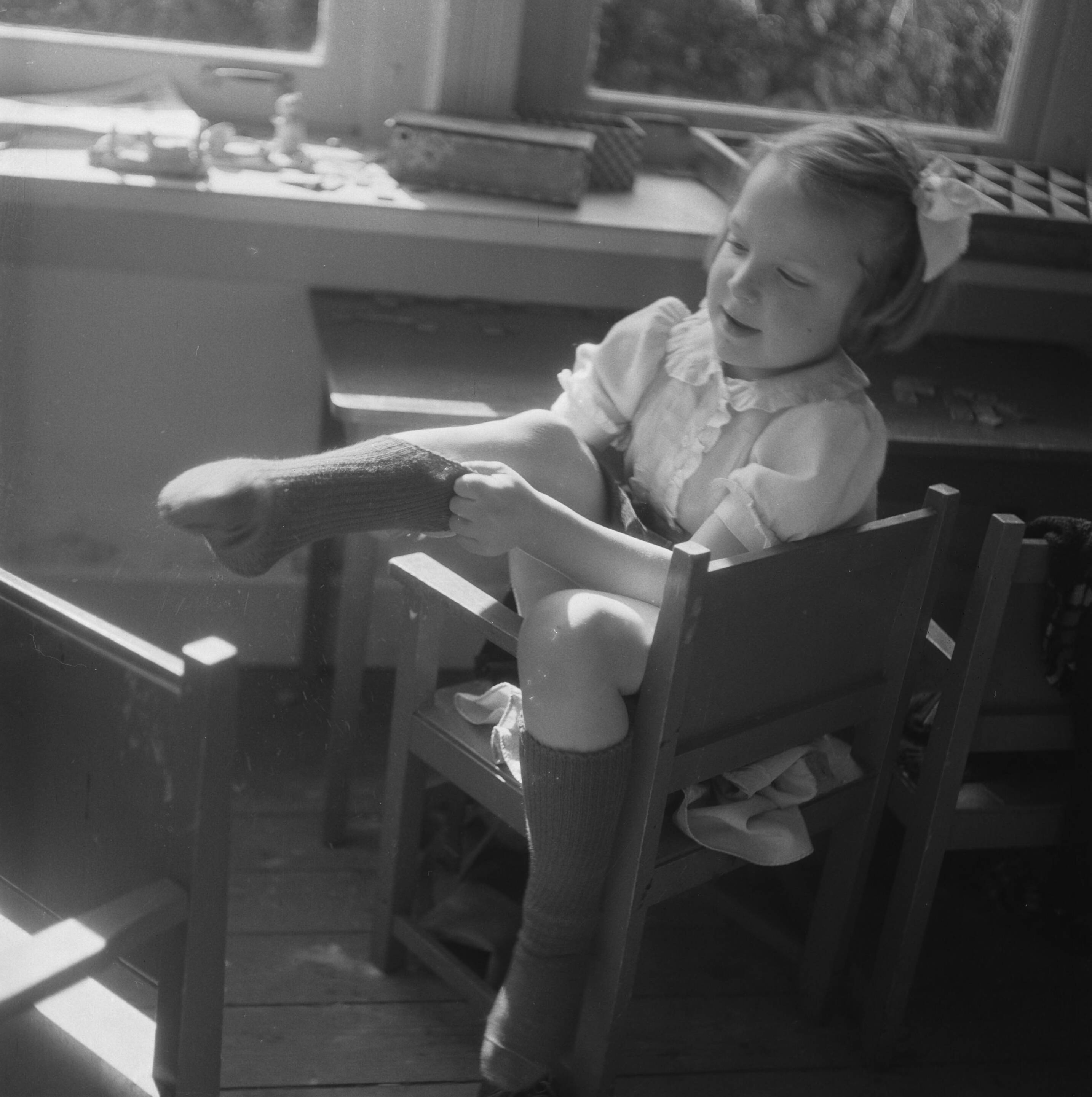 Prinses Beatrix en prinses Irene op de Werkplaats Kindergemeenschap van Kees Boeke te Bilthoven — De Werkplaats Kindergemeenschap van Kees Boeke. Prinses Irene trekt een sok aan — Foto: Breijer, Charles / Anefo. Licentie: Set B: Rechtenvrij / Publiek Domein. Bron: Nationaal Archief. http://hdl.handle.net/10648/a89aa3ca-d0b4-102d-bcf8-003048976d84