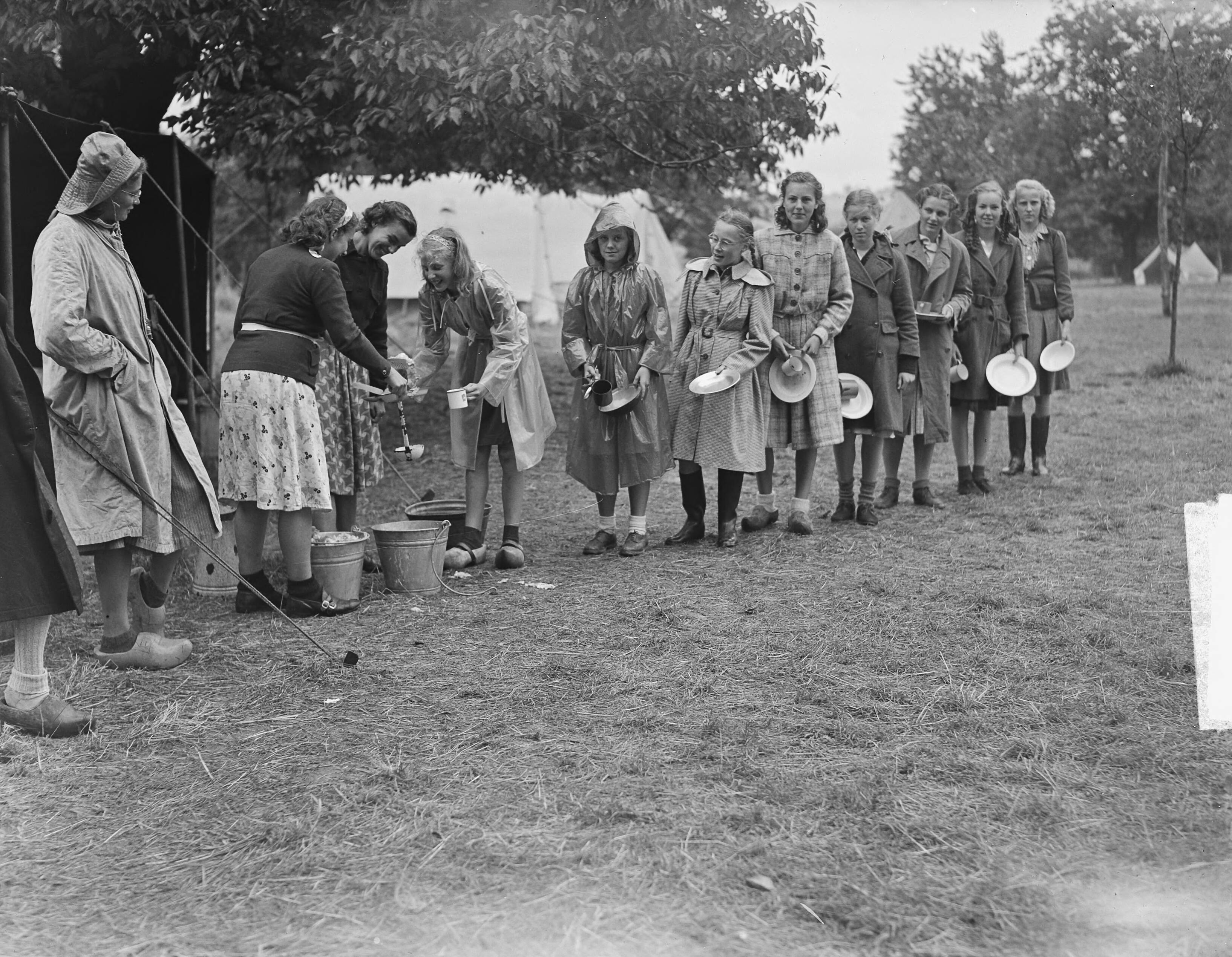 Fotocollectie Anefo — Kamp Mheer. Meisjes halen eten — Foto: Oorschot, […] van / Anefo. Licentie: Set B: Rechtenvrij / Publiek Domein. Bron: Nationaal Archief. http://hdl.handle.net/10648/a8cc44e8-d0b4-102d-bcf8-003048976d84