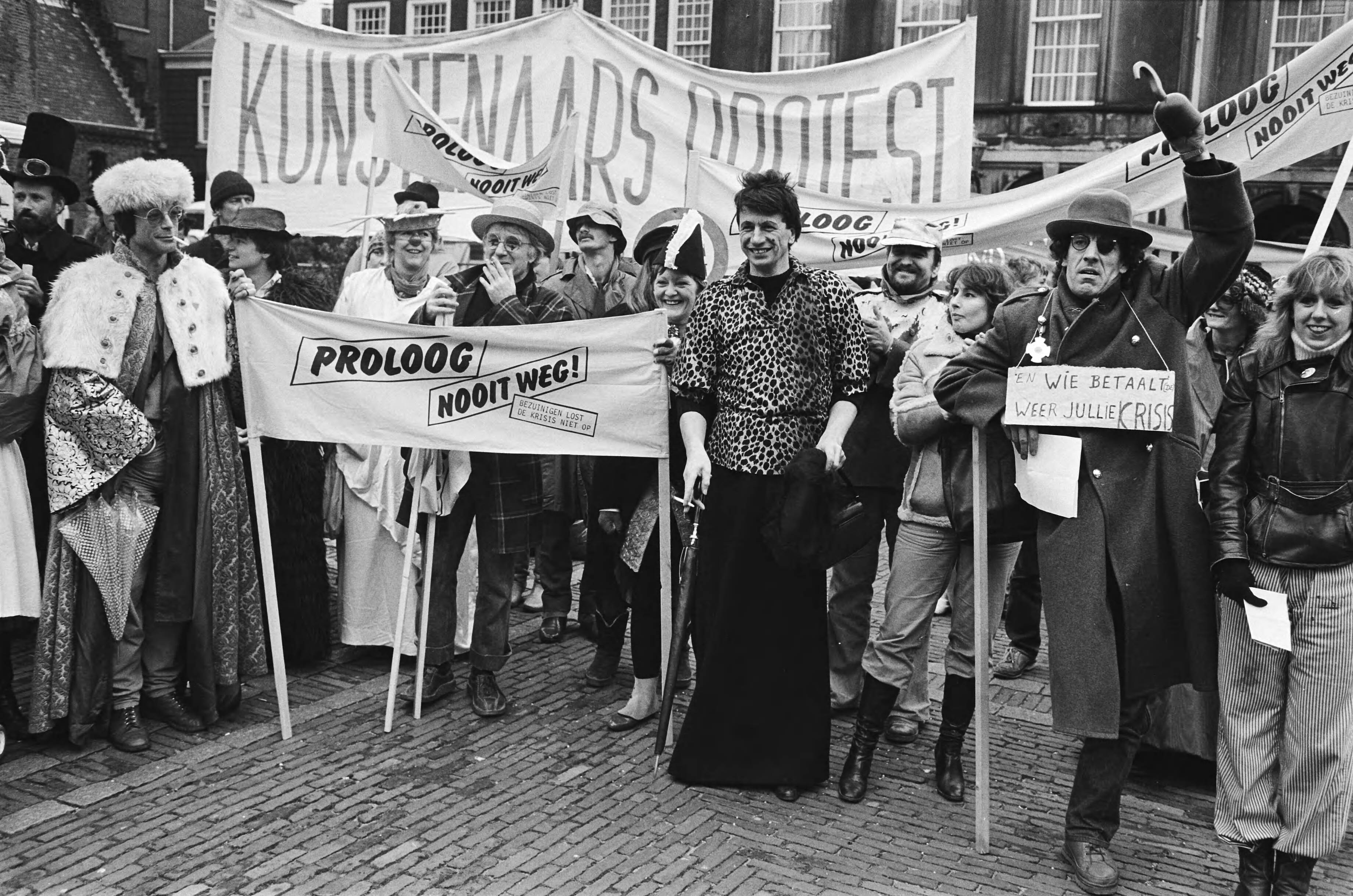 Demonstratie van kunstenaars op het Binnenhof, met Proloog en de Nieuwe Komedie — Proloog|Den Haag|Zuid-Holland|demonstraties |artiesten |spandoeken |kostuums|Binnenhof |Nieuwe Komedie — Foto: Antonisse, Marcel / Anefo. Licentie: Set B: Rechtenvrij / Publiek Domein. Bron: Nationaal Archief. http://hdl.handle.net/10648/ad220d16-d0b4-102d-bcf8-003048976d84
