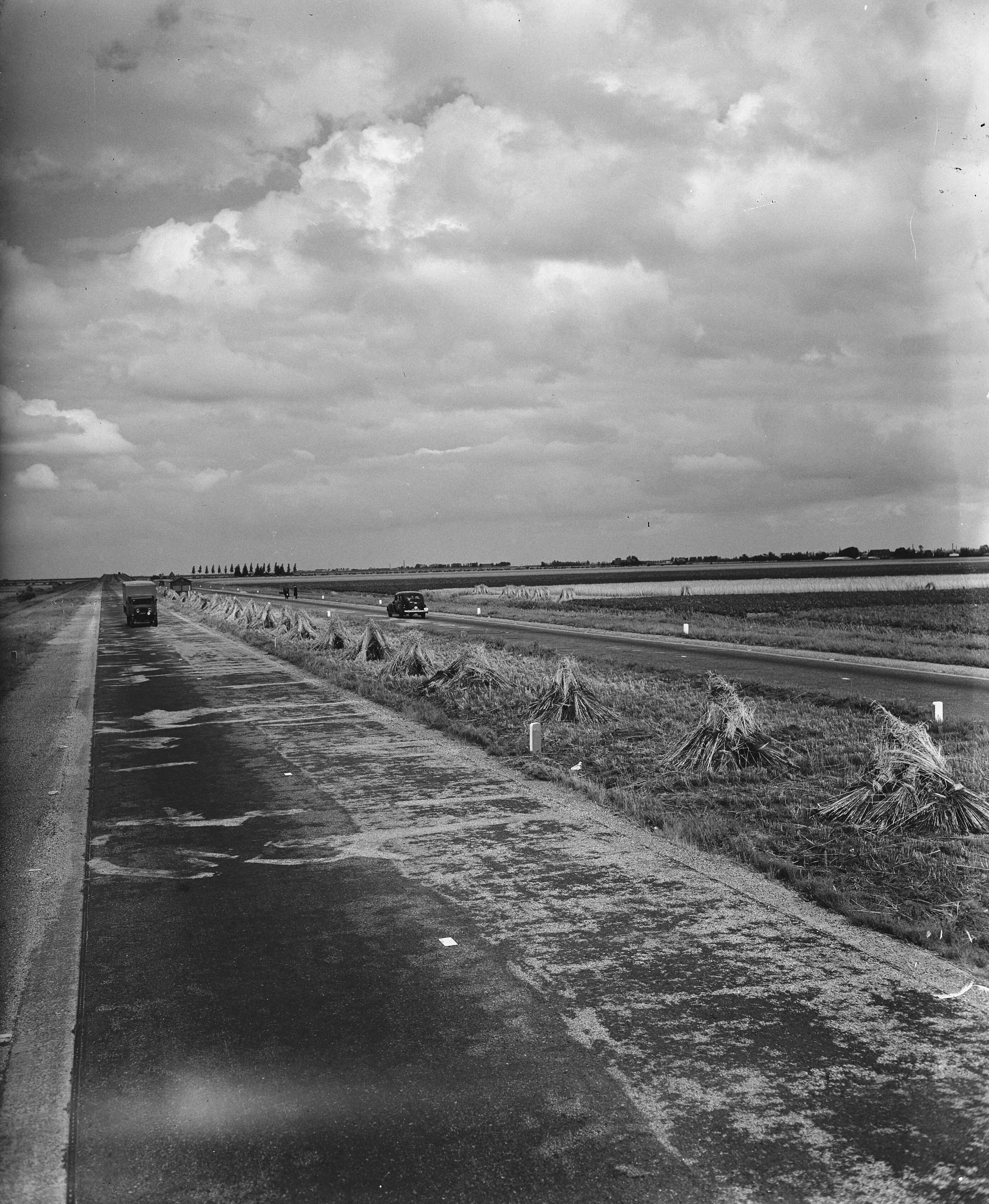 Fotocollectie Anefo — Weg bij Den Haag met korenschoven in de middenberm — Foto: Raucamp, Koos / Anefo. Licentie: Set B: Rechtenvrij / Publiek Domein. Bron: Nationaal Archief. http://hdl.handle.net/10648/a8a0f126-d0b4-102d-bcf8-003048976d84
