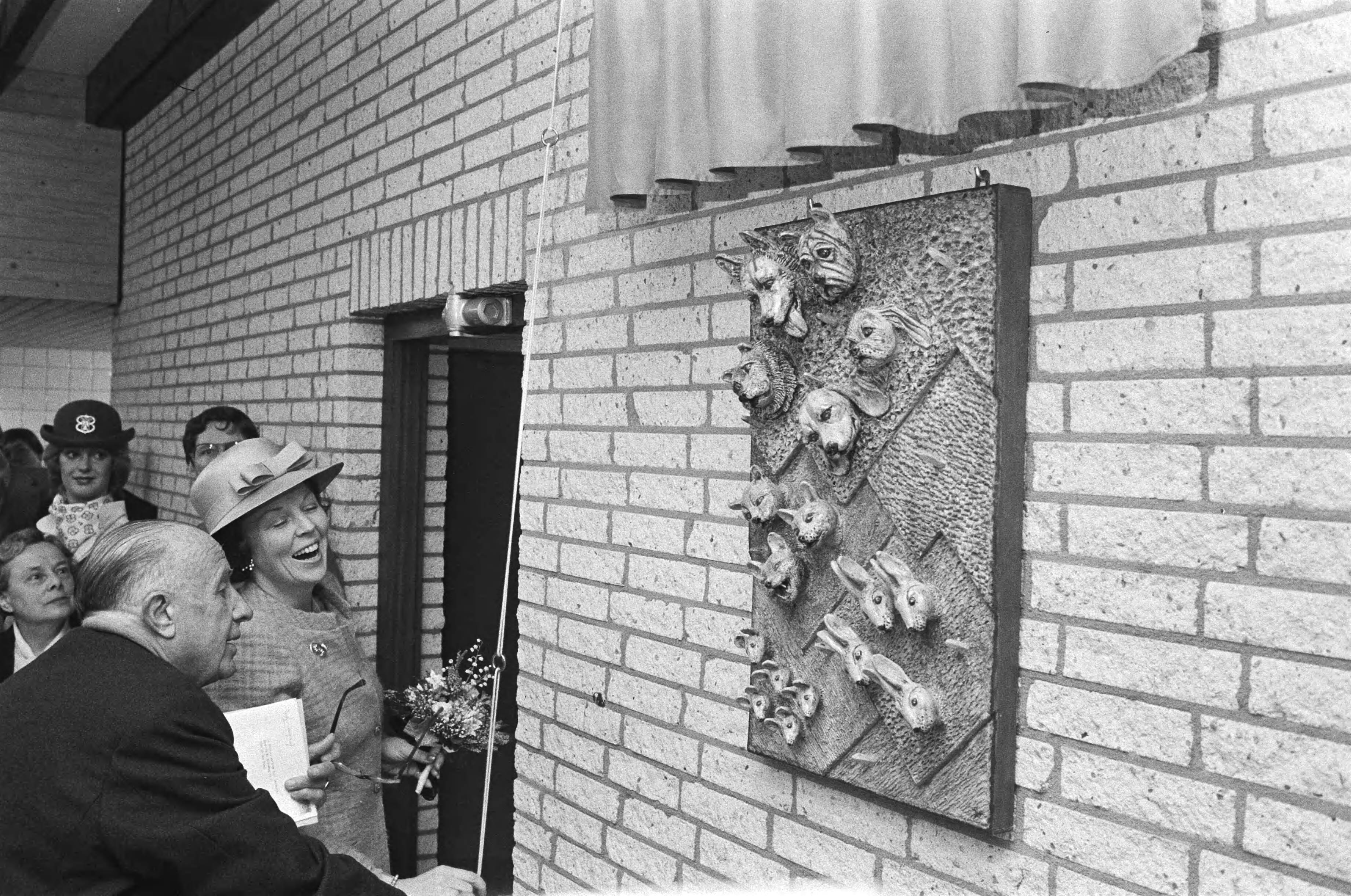 Fotocollectie Anefo — Beatrix opent het Haagse Dierencentrum in Den Haag . Beatrix onthult een kunstwerk met dierenkoppen in het dierencentrum — Foto: Antonisse, Marcel / Anefo. Licentie: Set B: Rechtenvrij / Publiek Domein. Bron: Nationaal Archief. http://hdl.handle.net/10648/ad136bf8-d0b4-102d-bcf8-003048976d84