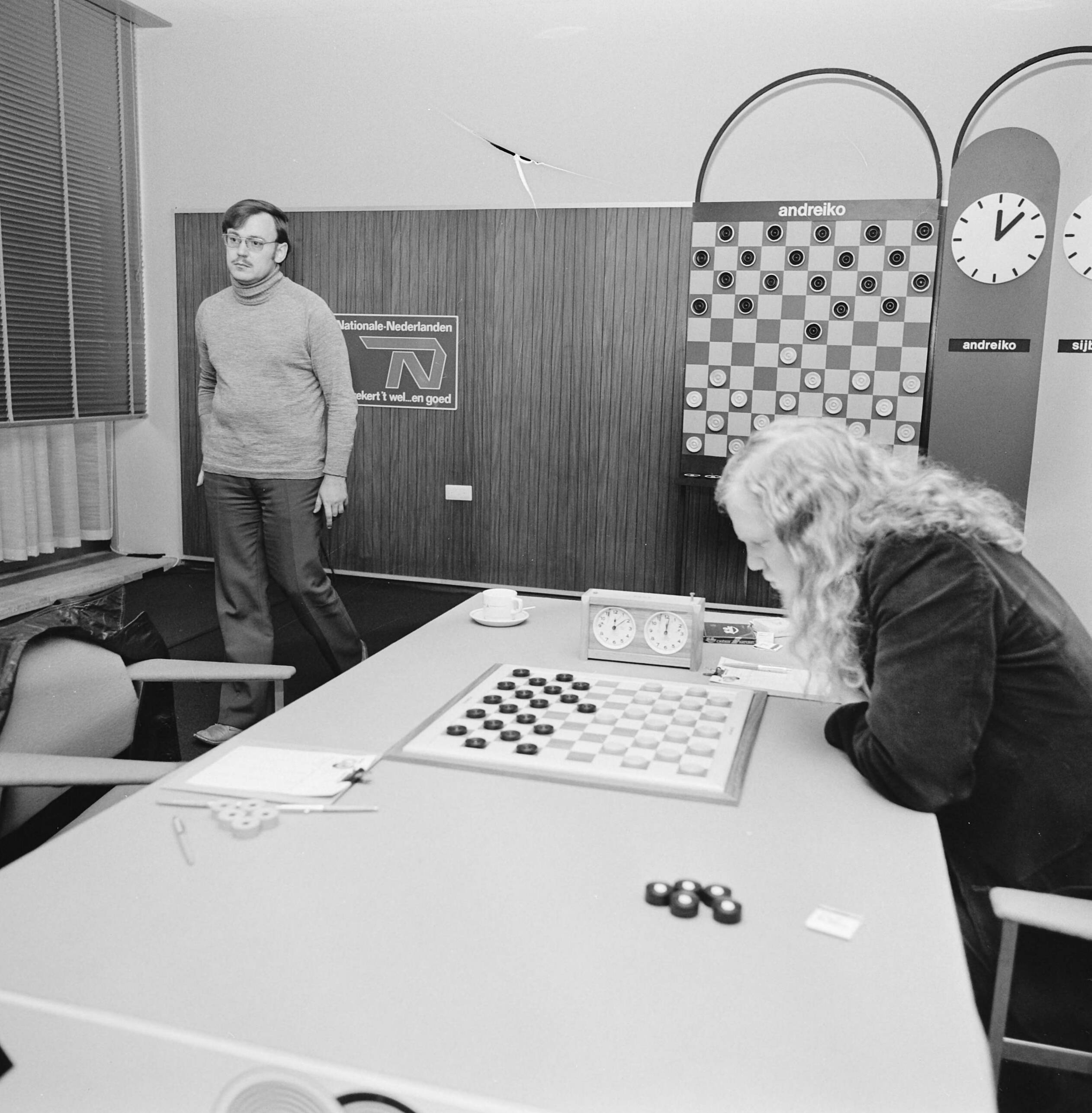 Fotocollectie Anefo — Wereldkampioenschap dammen te Den Haag , Sijbrands zittend en Andreiko lopend — Foto: Mieremet, Rob / Anefo. Licentie: Set B: Rechtenvrij / Publiek Domein. Bron: Nationaal Archief. http://hdl.handle.net/10648/ac399554-d0b4-102d-bcf8-003048976d84