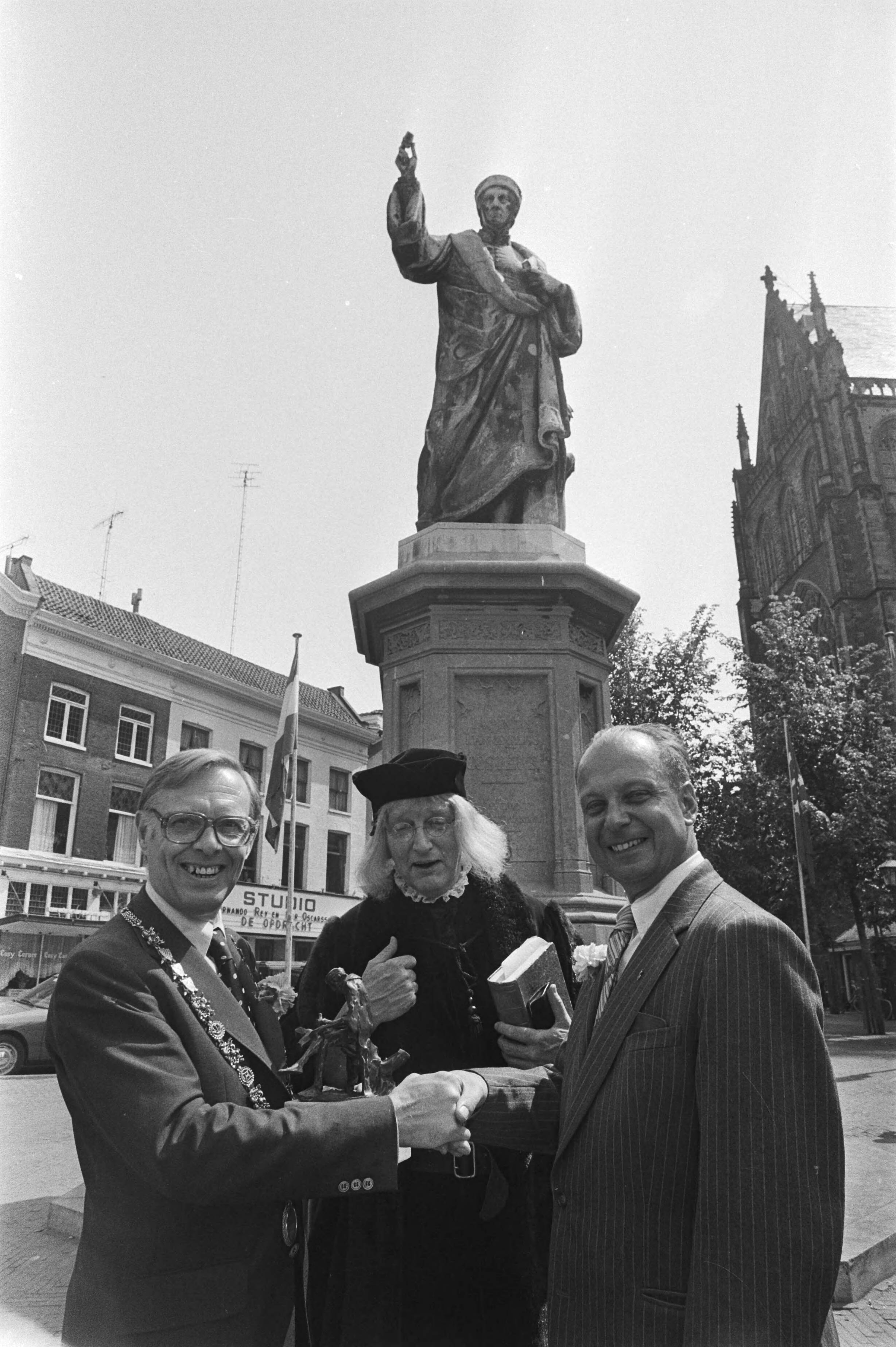 Fotocollectie Anefo — Laurens Jansz. Costerprijs voor boekhandelaar De Slegte uitgereikt in Haarlem; burgemeester Reehorst en De Slegte onder beeld Laurens Jansz. Coster — Foto: Suyk, Koen / Anefo. Licentie: Set B: Rechtenvrij / Publiek Domein. Bron: Nationaal Archief. http://hdl.handle.net/10648/acb50770-d0b4-102d-bcf8-003048976d84