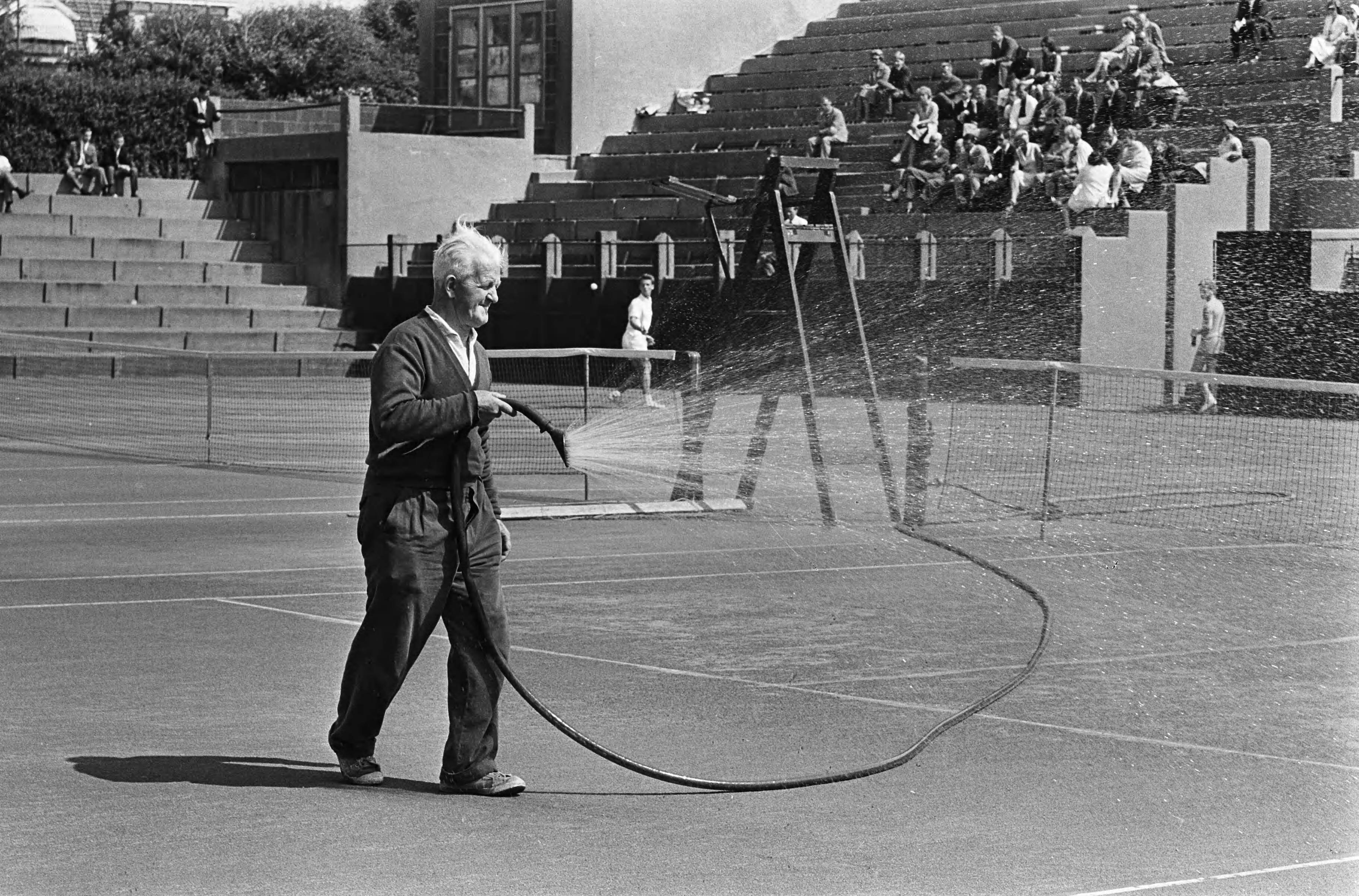 Fotocollectie Anefo — Nederlandse tenniskampioenschappen op de METS-banen. De baan wordt nat gespoten — Foto: Koch, Eric / Anefo. Licentie: Set B: Rechtenvrij / Publiek Domein. Bron: Nationaal Archief. http://hdl.handle.net/10648/aaba47aa-d0b4-102d-bcf8-003048976d84