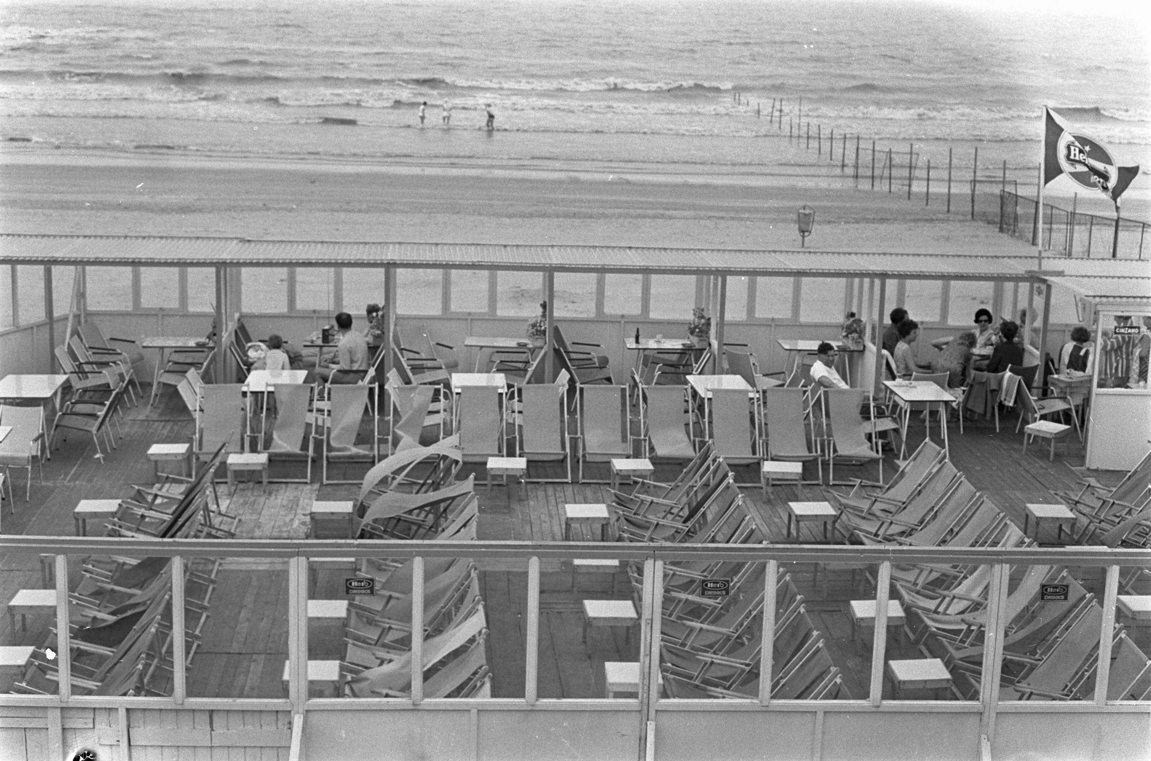 Zomer 1967 — Enthousiaste buitenlanders zoeken een plaatsje uit de wind — Foto: Fotograaf Onbekend / Anefo. Licentie: Set B: Rechtenvrij / Publiek Domein. Bron: Nationaal Archief. http://hdl.handle.net/10648/ab1da160-d0b4-102d-bcf8-003048976d84