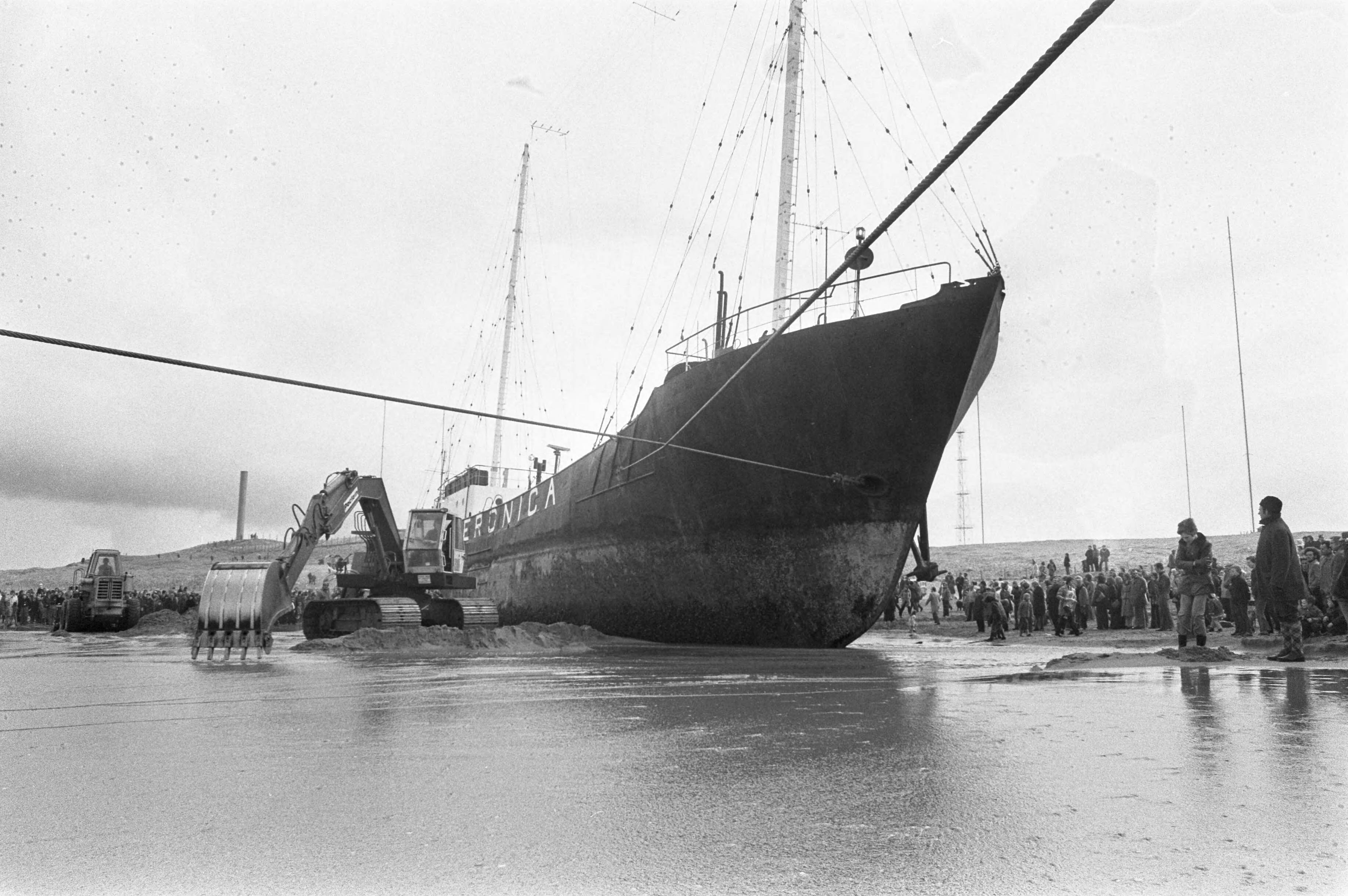Fotocollectie Anefo — Werkzaamheden bij gestrande radio-zendschip Veronica op strand bij Scheveningen — Foto: Peters, Hans / Anefo. Licentie: Set B: Rechtenvrij / Publiek Domein. Bron: Nationaal Archief. http://hdl.handle.net/10648/ac28fe60-d0b4-102d-bcf8-003048976d84