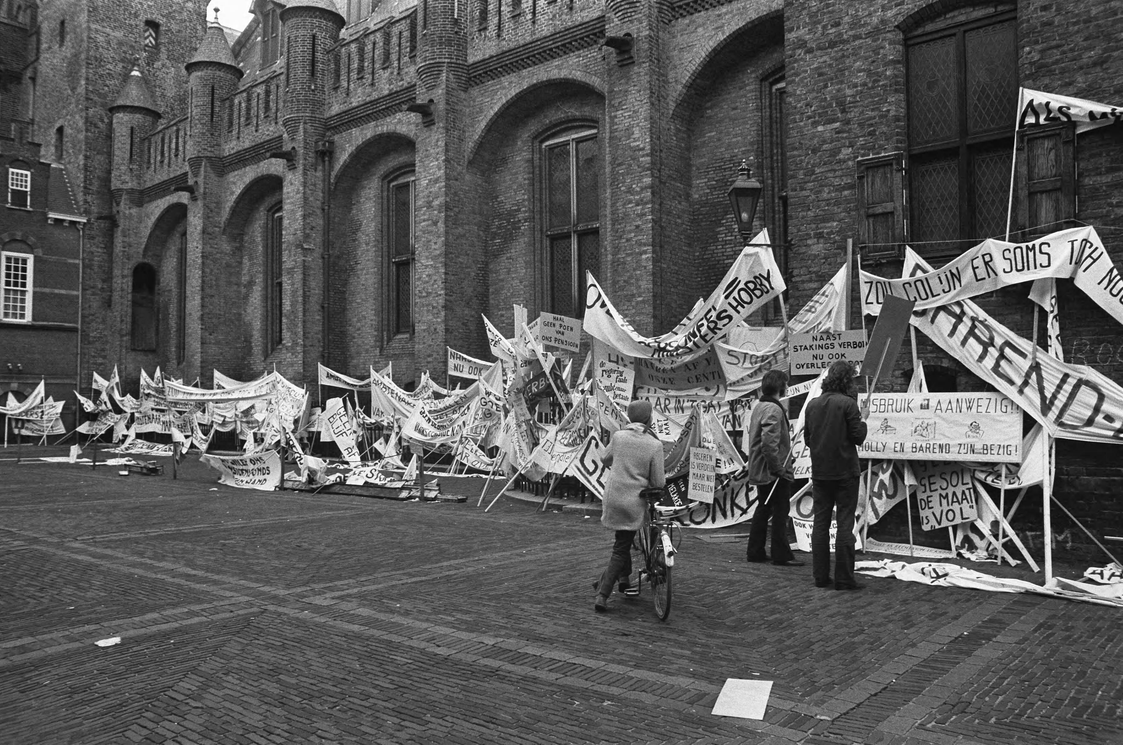 Fotocollectie Anefo — Ambtenaren (meer dan 40.000) demonstreren in Den Haag , spandoeken tegen muur na betoging — Foto: Peters, Hans / Anefo. Licentie: Set B: Rechtenvrij / Publiek Domein. Bron: Nationaal Archief. http://hdl.handle.net/10648/ac245d06-d0b4-102d-bcf8-003048976d84