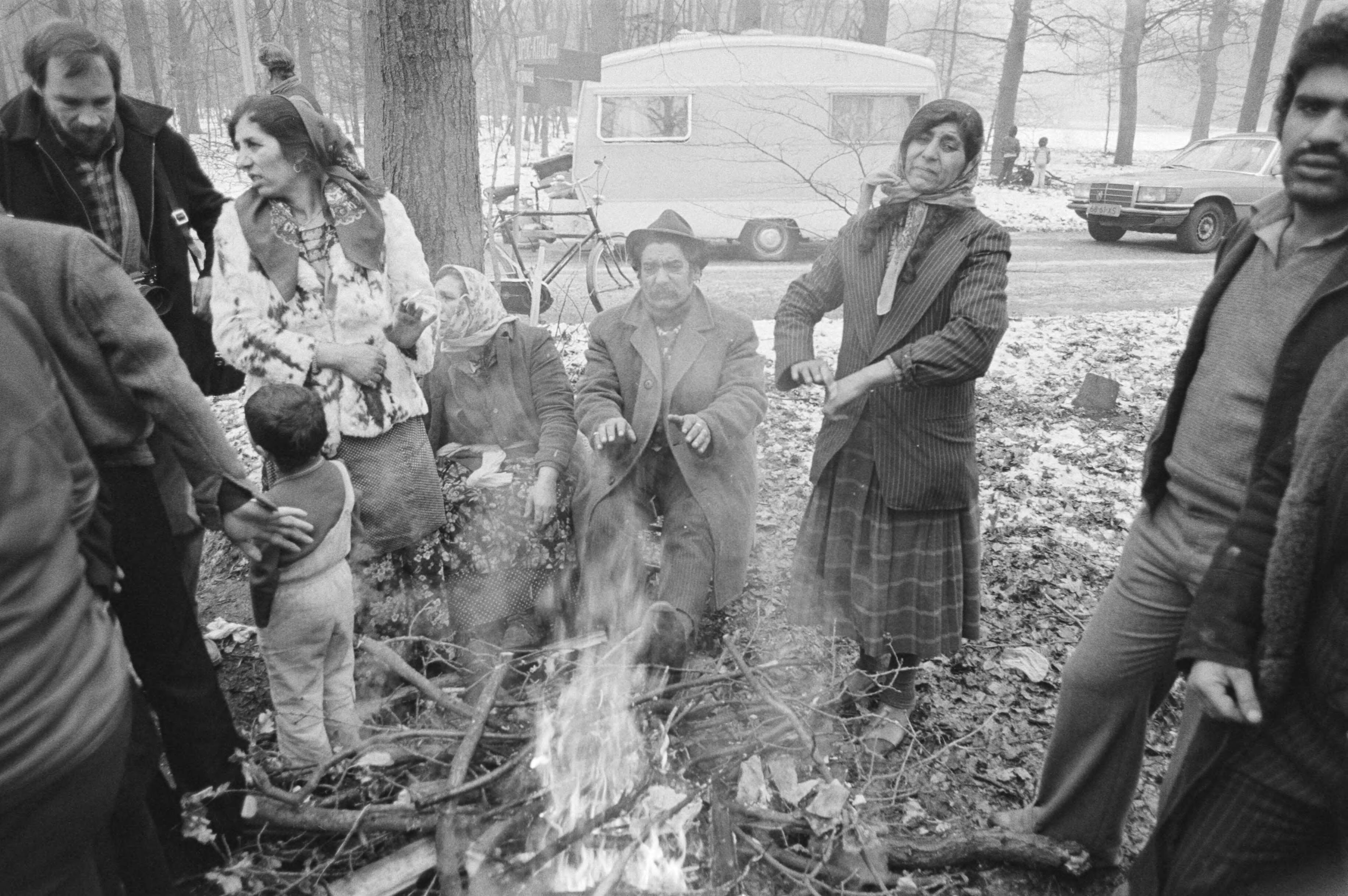 Fotocollectie Anefo — Sinds vannacht staat er een groep zigeuners op terrein van Bisdom Utrecht in Zeist, enkele zigeuners verwarmen zich bij kampvuurtje — Foto: Antonisse, Marcel / Anefo. Licentie: Set B: Rechtenvrij / Publiek Domein. Bron: Nationaal Archief. http://hdl.handle.net/10648/acf1df9c-d0b4-102d-bcf8-003048976d84