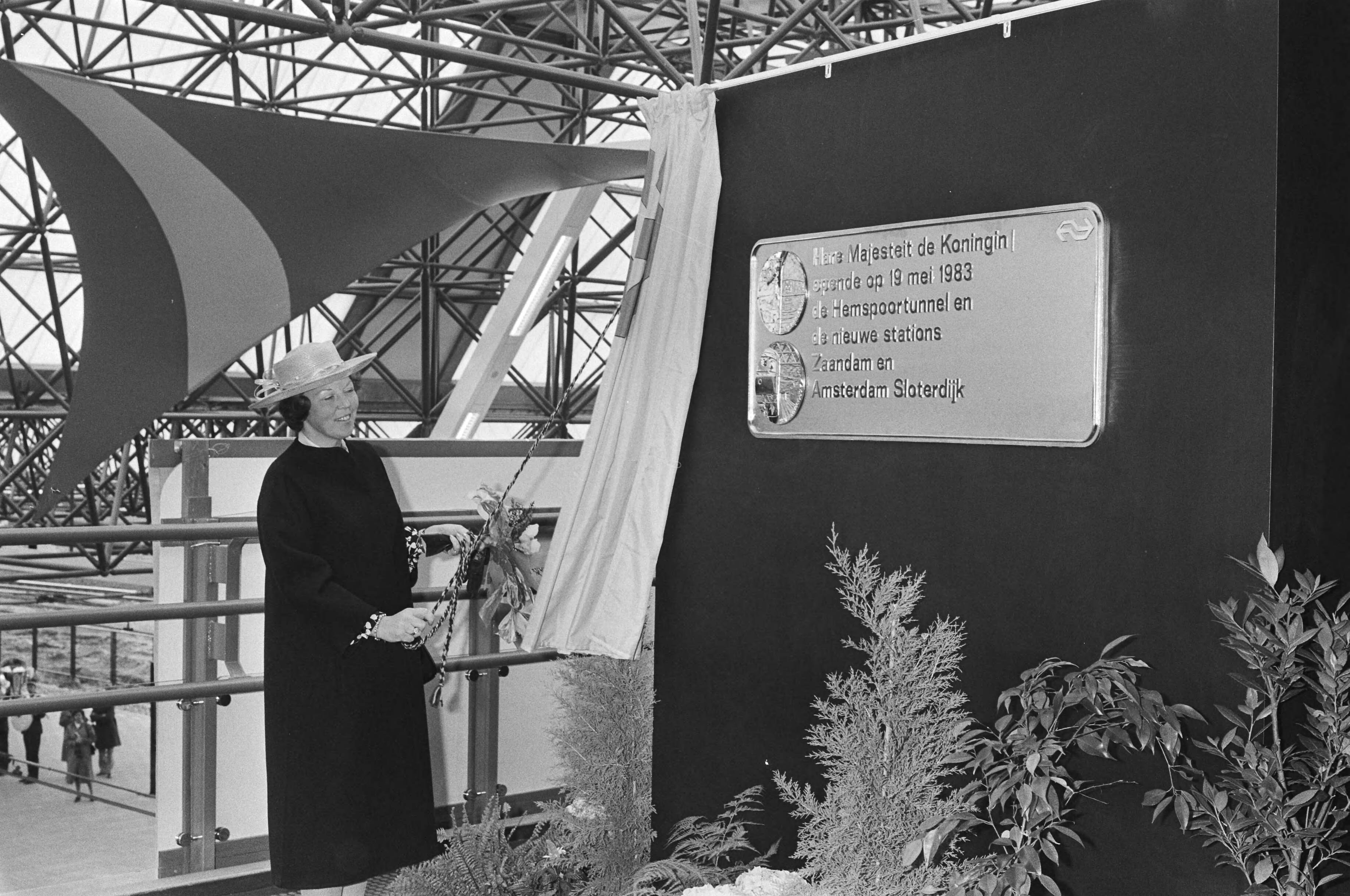 Opening van het Hemspoortraject door koningin Beatrix in Zaandam — Koningin Beatrix onthult een plaquette op station Zaandam — Foto: Croes, Rob C. / Anefo. Licentie: Set B: Rechtenvrij / Publiek Domein. Bron: Nationaal Archief. http://hdl.handle.net/10648/ad2988de-d0b4-102d-bcf8-003048976d84