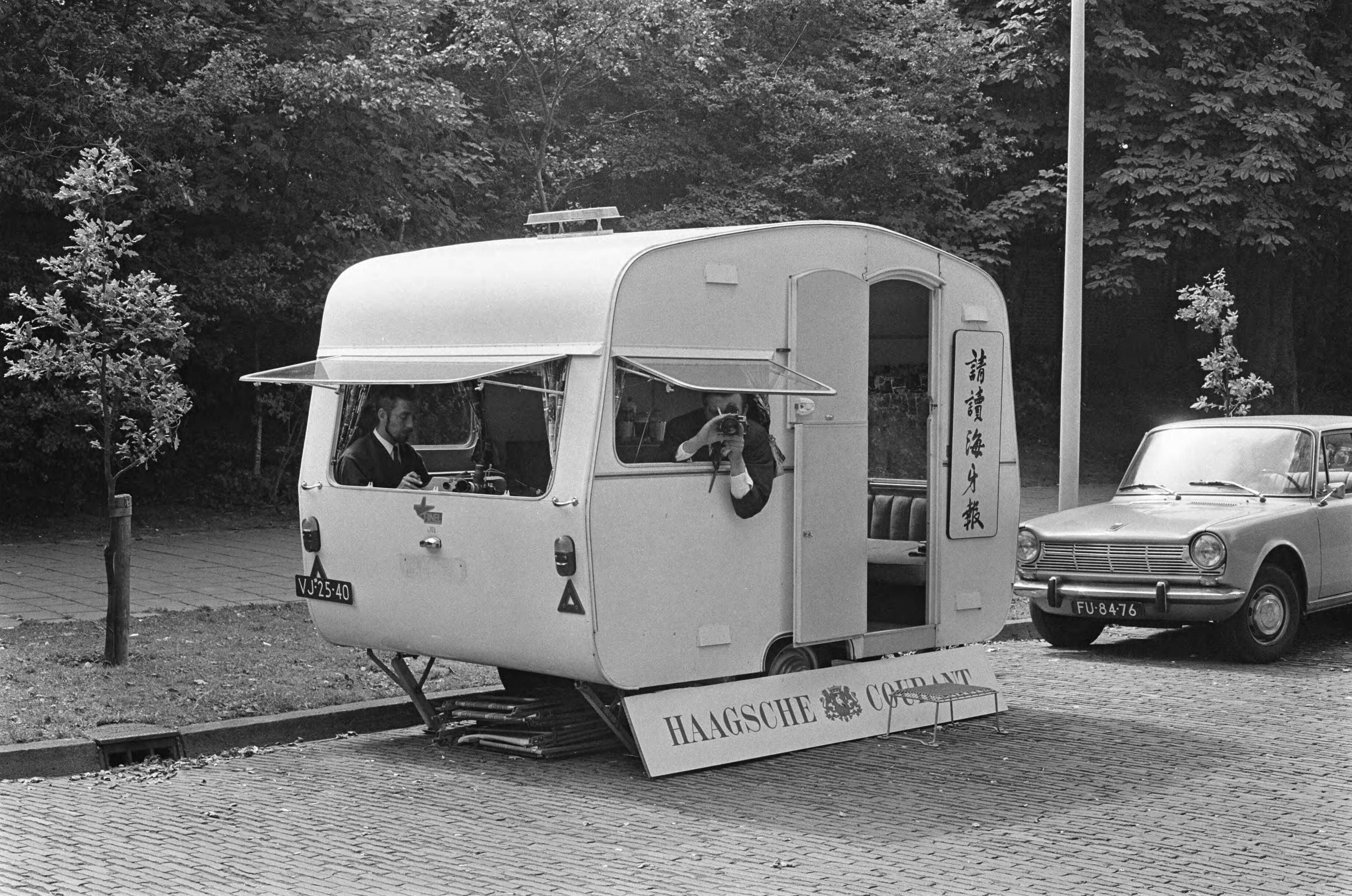 Fotocollectie Anefo — Chinese legatie te Den Haag , caravan van Haagse Courant met verslaggever en fotograaf aan het posten — Foto: Kroon, Ron / Anefo. Licentie: Set B: Rechtenvrij / Publiek Domein. Bron: Nationaal Archief. http://hdl.handle.net/10648/aaf5cc26-d0b4-102d-bcf8-003048976d84