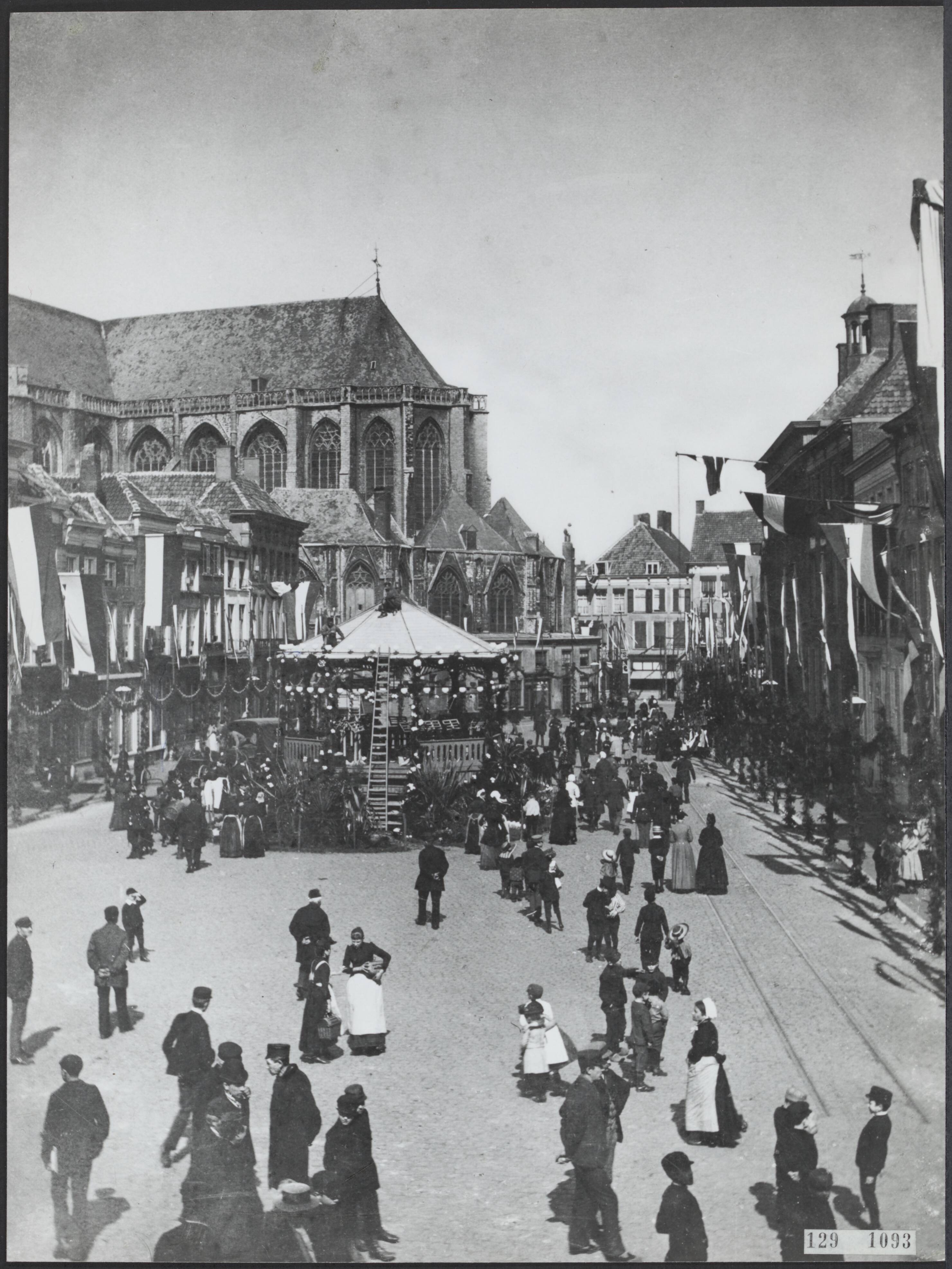 Fotocollectie Rijksvoorlichtingsdienst Eigen — Grote Kerk Breda [muziektent met publiek, er hangen vlaggen uit de huizen] — Foto: Onbekend / Publiek Domein of Rechtenvrij. Licentie: Set B: Rechtenvrij / Publiek Domein. Bron: Nationaal Archief. http://hdl.handle.net/10648/af48a73a-d0b4-102d-bcf8-003048976d84