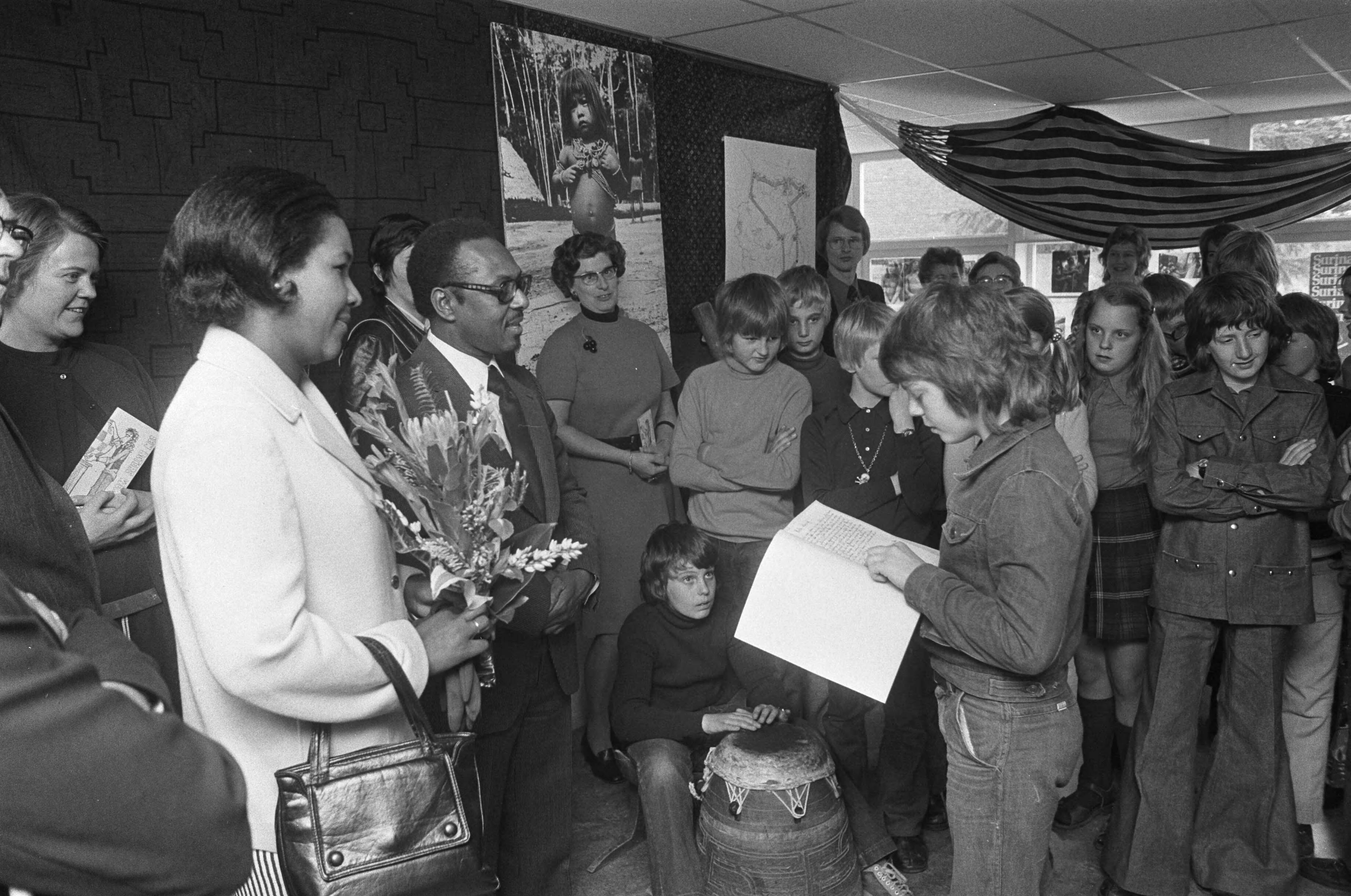 Gevolmachtigd minister Suriname mr. W. F. van Eer opent Suriname tentoonstelling in Hilversum — Een van de leerlingen leest open brief voor — Foto: Fotograaf Onbekend / Anefo. Licentie: Set B: Rechtenvrij / Publiek Domein. Bron: Nationaal Archief. http://hdl.handle.net/10648/ac4ab01e-d0b4-102d-bcf8-003048976d84