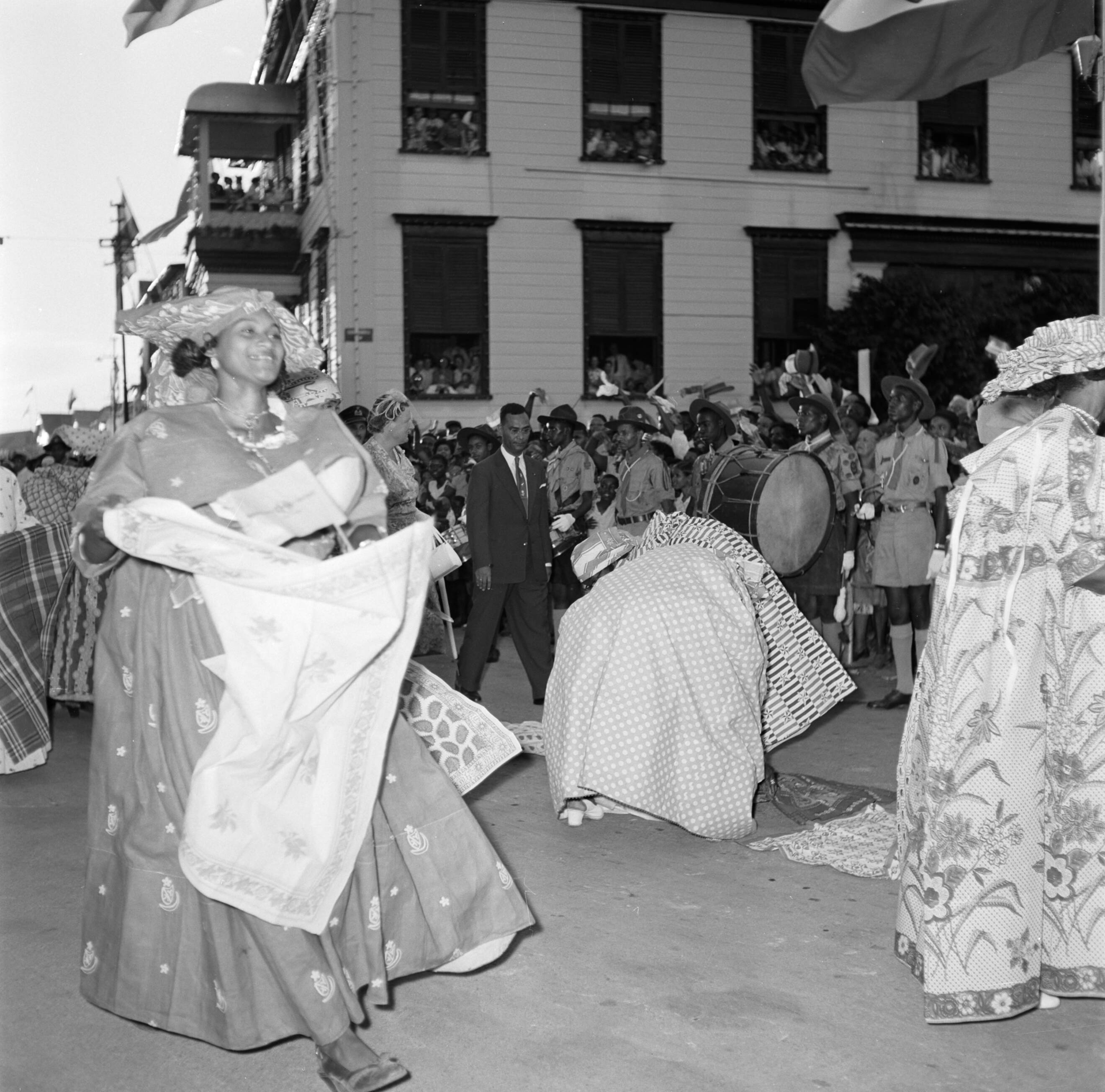 Nederlandse Antillen en Suriname ten tijde van het koninklijk bezoek van koningin Juliana en prins Bernhard in 1955 — De koningin loopt door Domburg. Op de voorgrond kotomisis — Foto: Poll, Willem van de. Licentie: Set B: Rechtenvrij / Publiek Domein. Bron: Nationaal Archief. http://hdl.handle.net/10648/aeb26662-d0b4-102d-bcf8-003048976d84