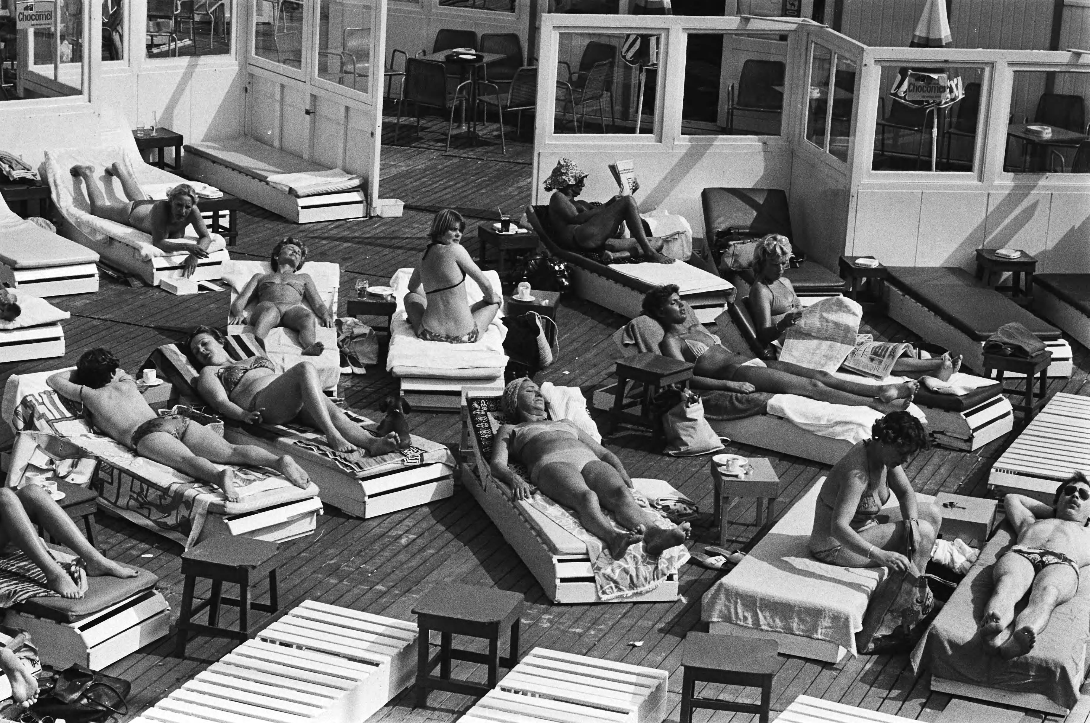 Mooi weer in Scheveningen — Zonnende mensen op strandterras — Foto: Suyk, Koen / Anefo. Licentie: Set B: Rechtenvrij / Publiek Domein. Bron: Nationaal Archief. http://hdl.handle.net/10648/acca0756-d0b4-102d-bcf8-003048976d84
