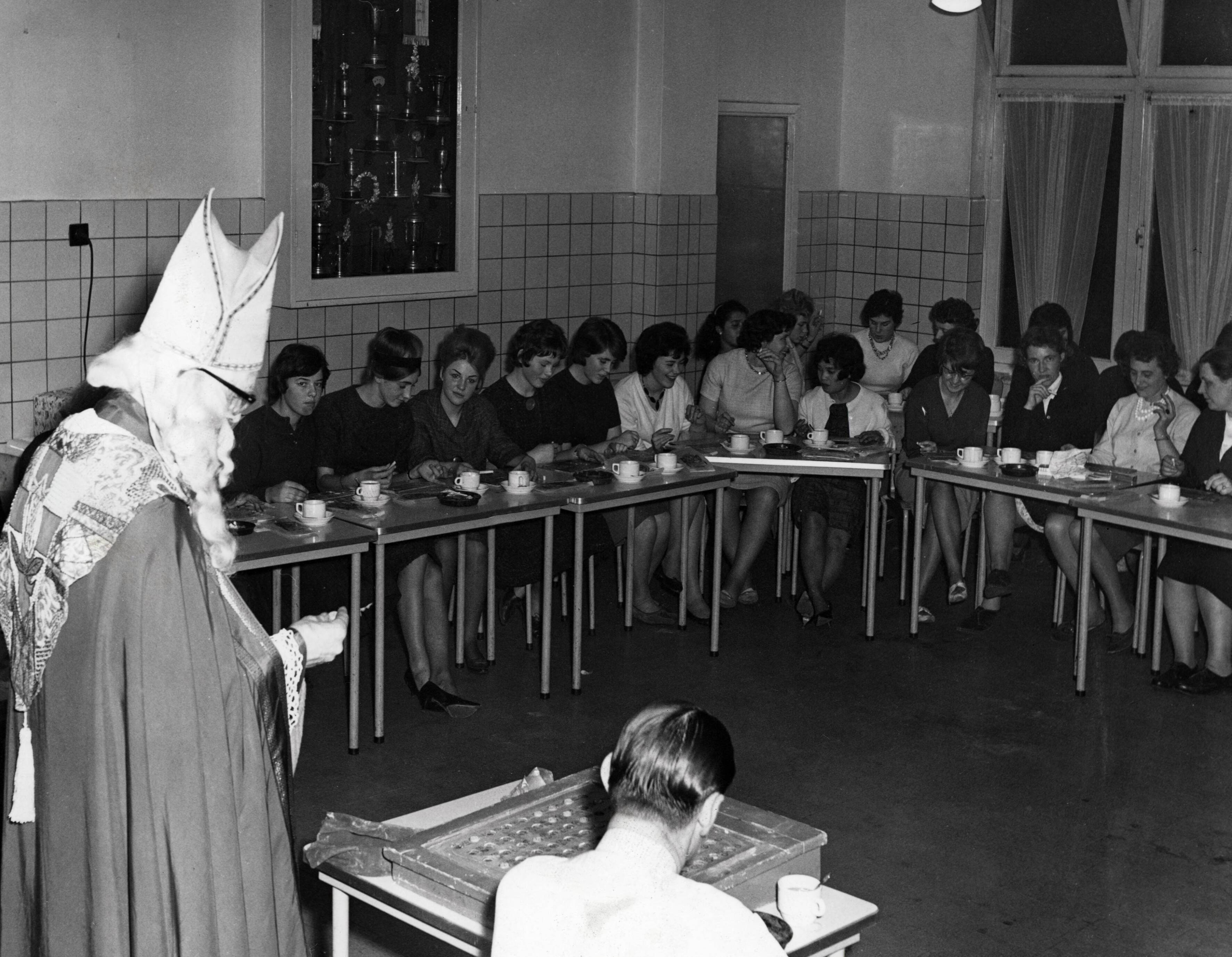 Collectie nader te bepalen — [Sinterklaasfeest N.V. Drukkerij De Spaarnestad in Haarlem] [Sinterklaas trekt de nummers tijdens het spel Bingo in de kantine van de Spaarnestad] — Foto: Fotograaf Onbekend / Fotobureau onbekend / Spaarnestad Photo (05887). Licentie: Set B: Rechtenvrij / Publiek Domein. Bron: Nationaal Archief. http://hdl.handle.net/10648/35429da6-4066-a382-e063-6df0900a6686