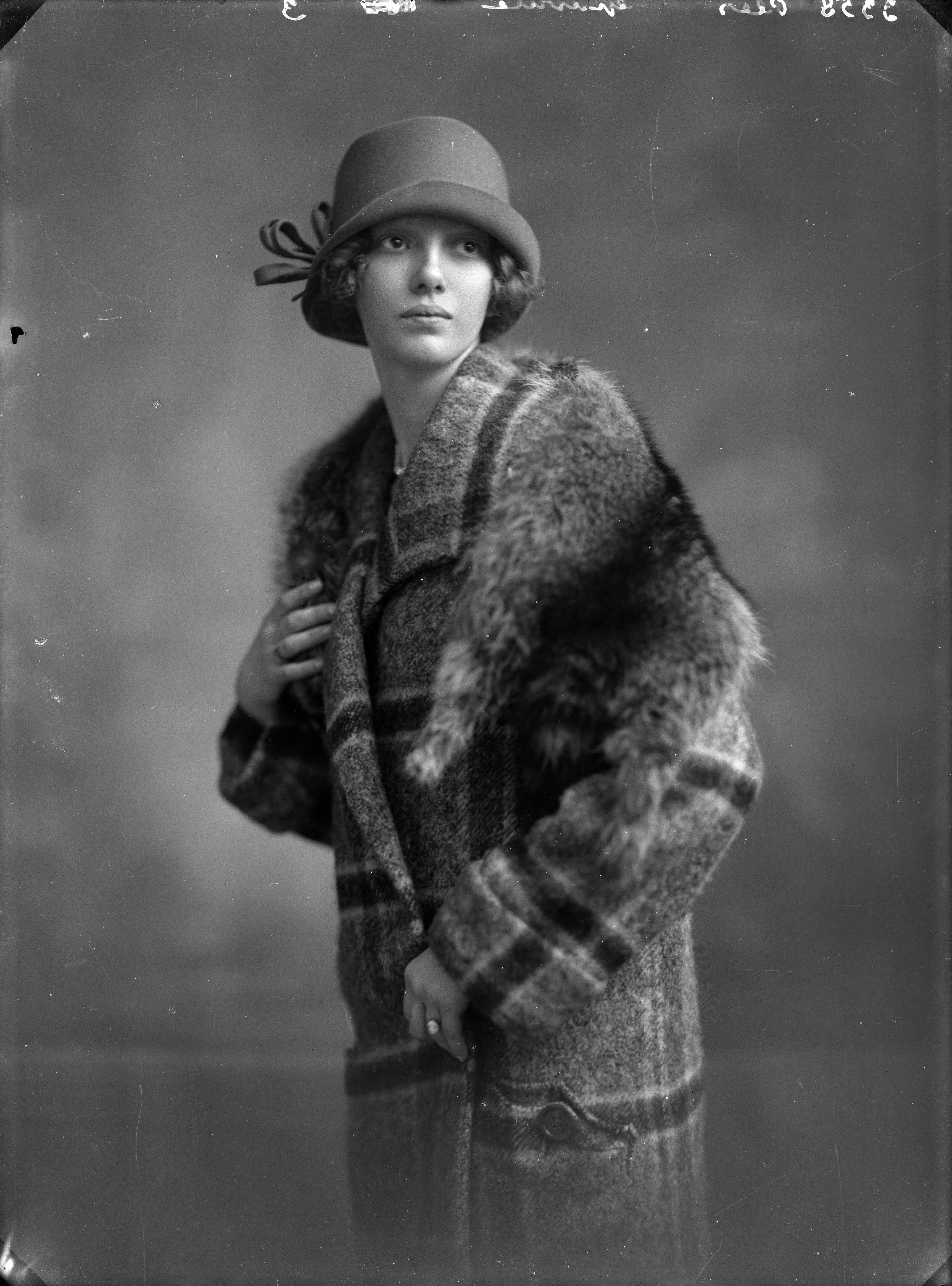 Portretten — Studio-opnames. Portret van een vrouw met wollen geruite jas met vossenbontje en pothoed met strik. Haarlem, Nederland. 1918-1930. 3358 Plas gravure 3 — Foto: Berg, Th.C.J. van den / Spaarnestad Photo (05887). Licentie: Set B: Rechtenvrij / Publiek Domein. Bron: Nationaal Archief. http://hdl.handle.net/10648/35429da7-c61f-a382-e063-6df0900a6686