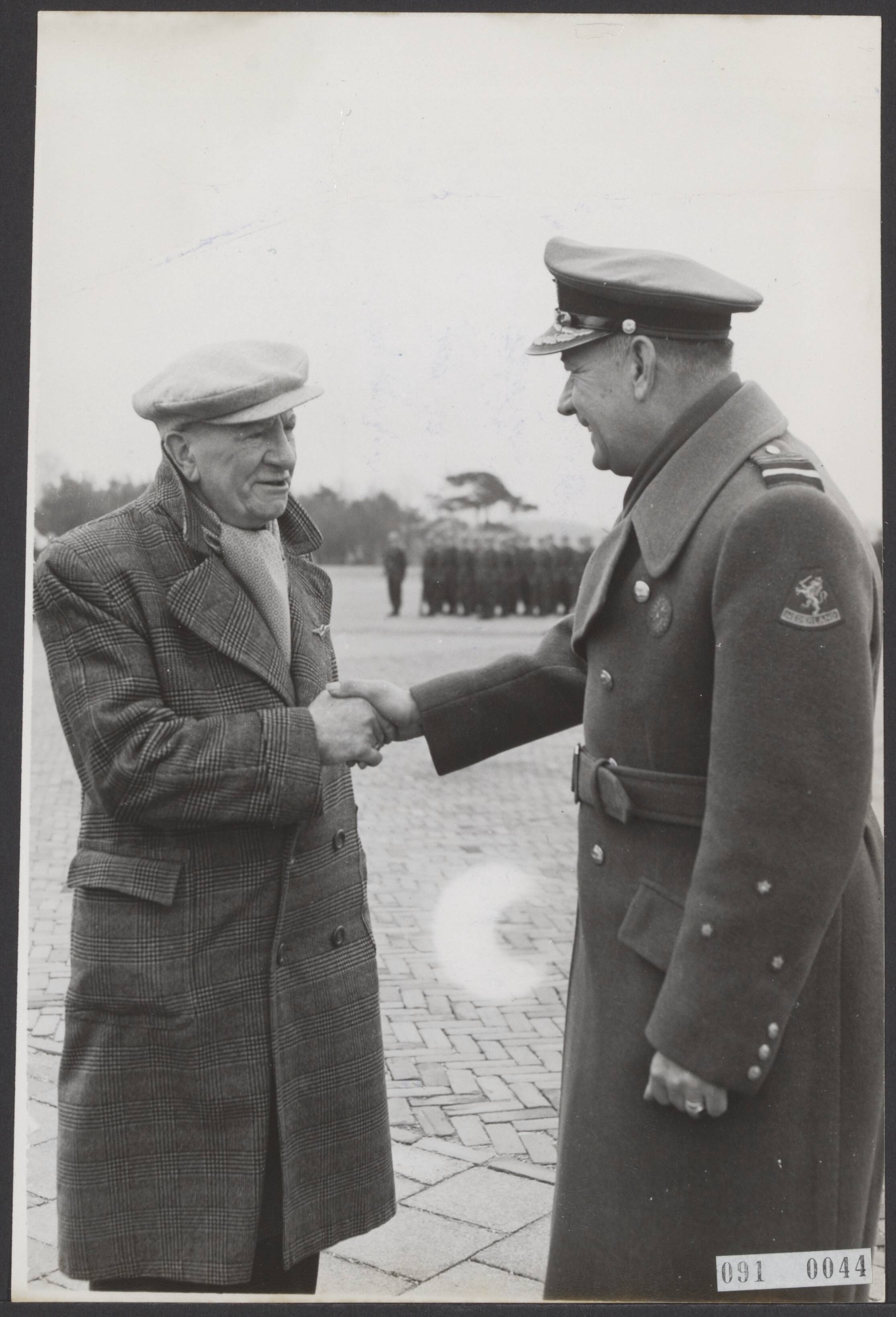 Fotocollectie Elsevier Binnenland — Op het vliegveld Soesterberg is het militair vliegbrevet uitgereikt aan Marinus van Meel, de eerste militaire vlieger in ons land. Luitenant-Generaal Baretta wenst van Meel geluk nadat hij de wing had opgespeld — Foto: Fotograaf Onbekend / Anefo. Licentie: Set B: Rechtenvrij / Publiek Domein. Bron: Nationaal Archief. http://hdl.handle.net/10648/ae1ed168-d0b4-102d-bcf8-003048976d84