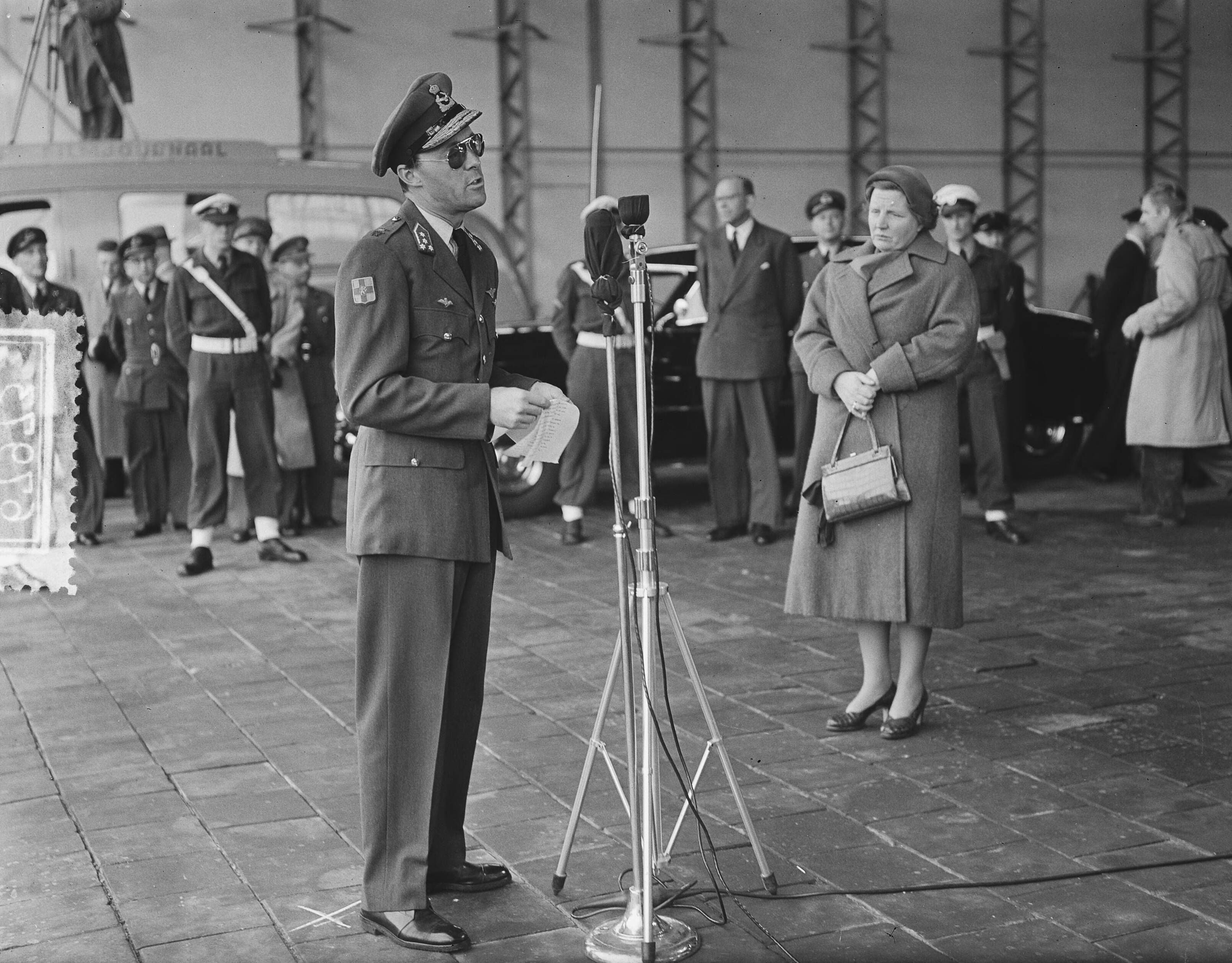 Prins Bernhard arriveert op Soesterberg na een reis naar Zuid-Afrika — Aankomst prins Bernhard op Soesterberg uit Zuid Afrika. Prins Bernhard achter de microfoon, rechts koningin Juliana — Foto: Bilsen, Joop van / Anefo. Licentie: Set B: Rechtenvrij / Publiek Domein. Bron: Nationaal Archief. http://hdl.handle.net/10648/a92ba938-d0b4-102d-bcf8-003048976d84