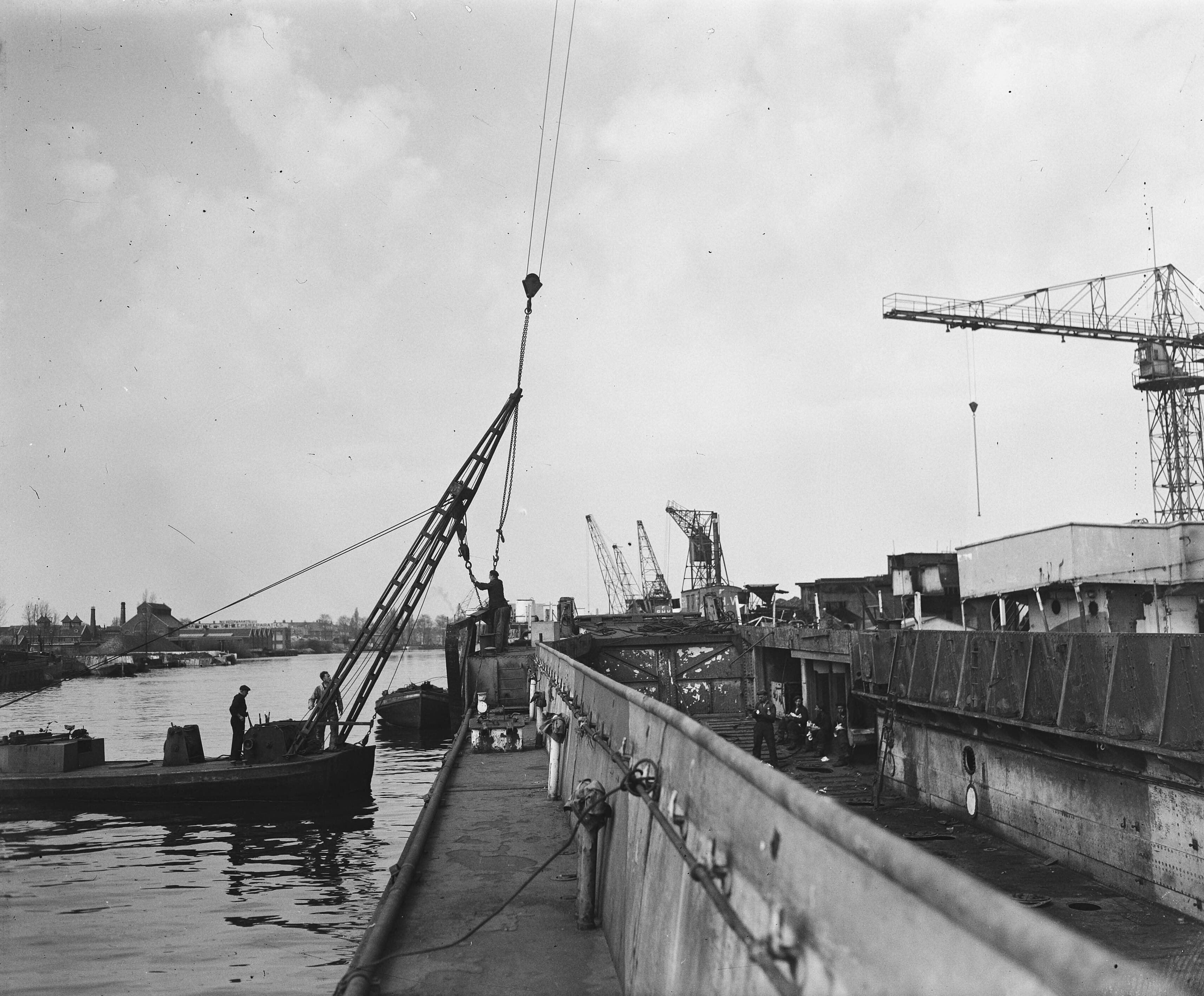 Landingsvaartuigen bij Werf Verschure & Co te Amsterdam — Landingsvaartuigen worden omgebouwd tot vrachtschepen bij Werf Verschure & Co te Amsterdam — Foto: Zeylemaker, Co / Anefo. Licentie: Set B: Rechtenvrij / Publiek Domein. Bron: Nationaal Archief. http://hdl.handle.net/10648/a8a6fed6-d0b4-102d-bcf8-003048976d84