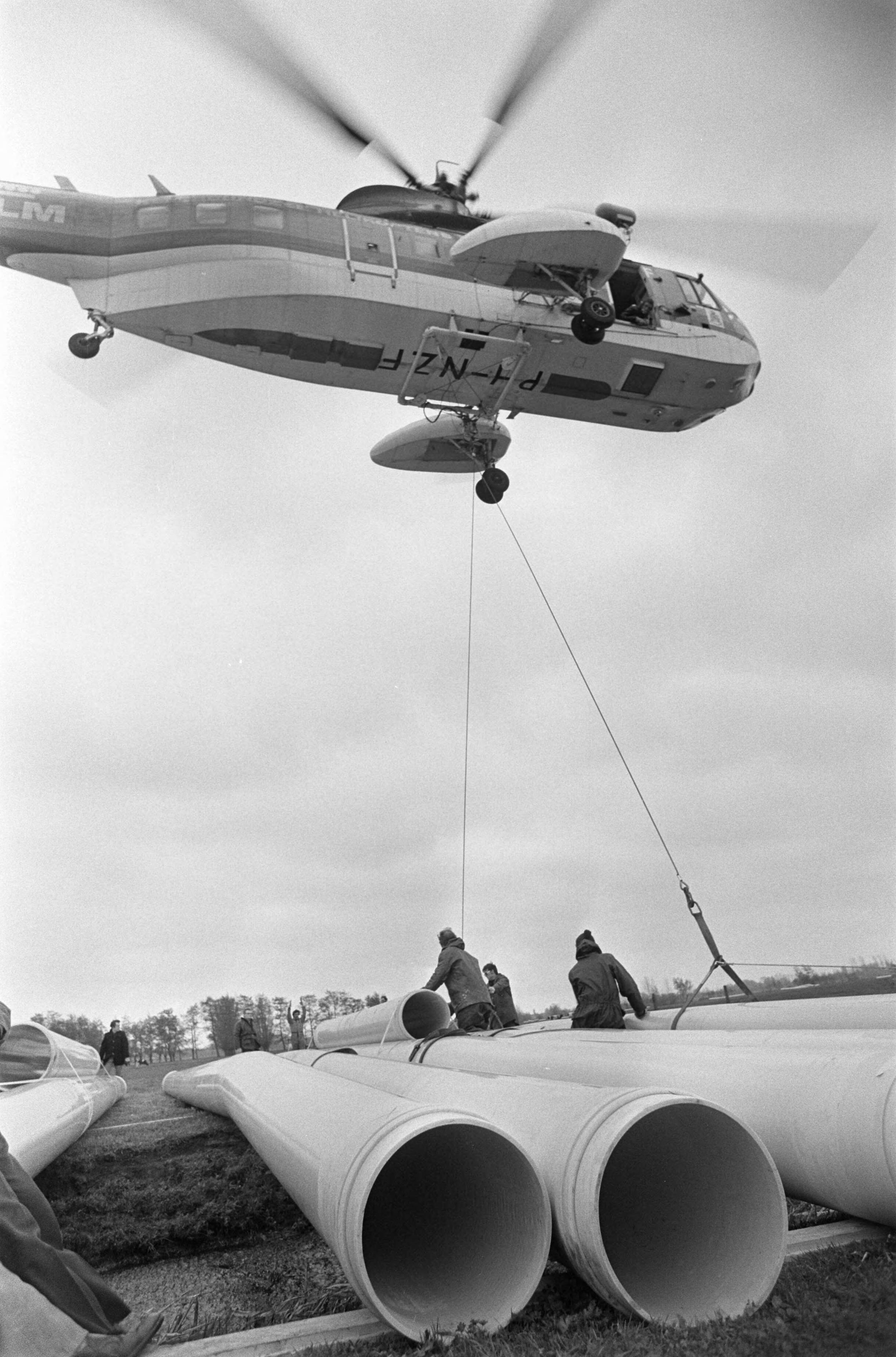 Fotocollectie Anefo — Waterleidingbuizen per helicopter gelegd bij Woerden — Foto: Suyk, Koen / Anefo. Licentie: Set B: Rechtenvrij / Publiek Domein. Bron: Nationaal Archief. http://hdl.handle.net/10648/ac8f9788-d0b4-102d-bcf8-003048976d84