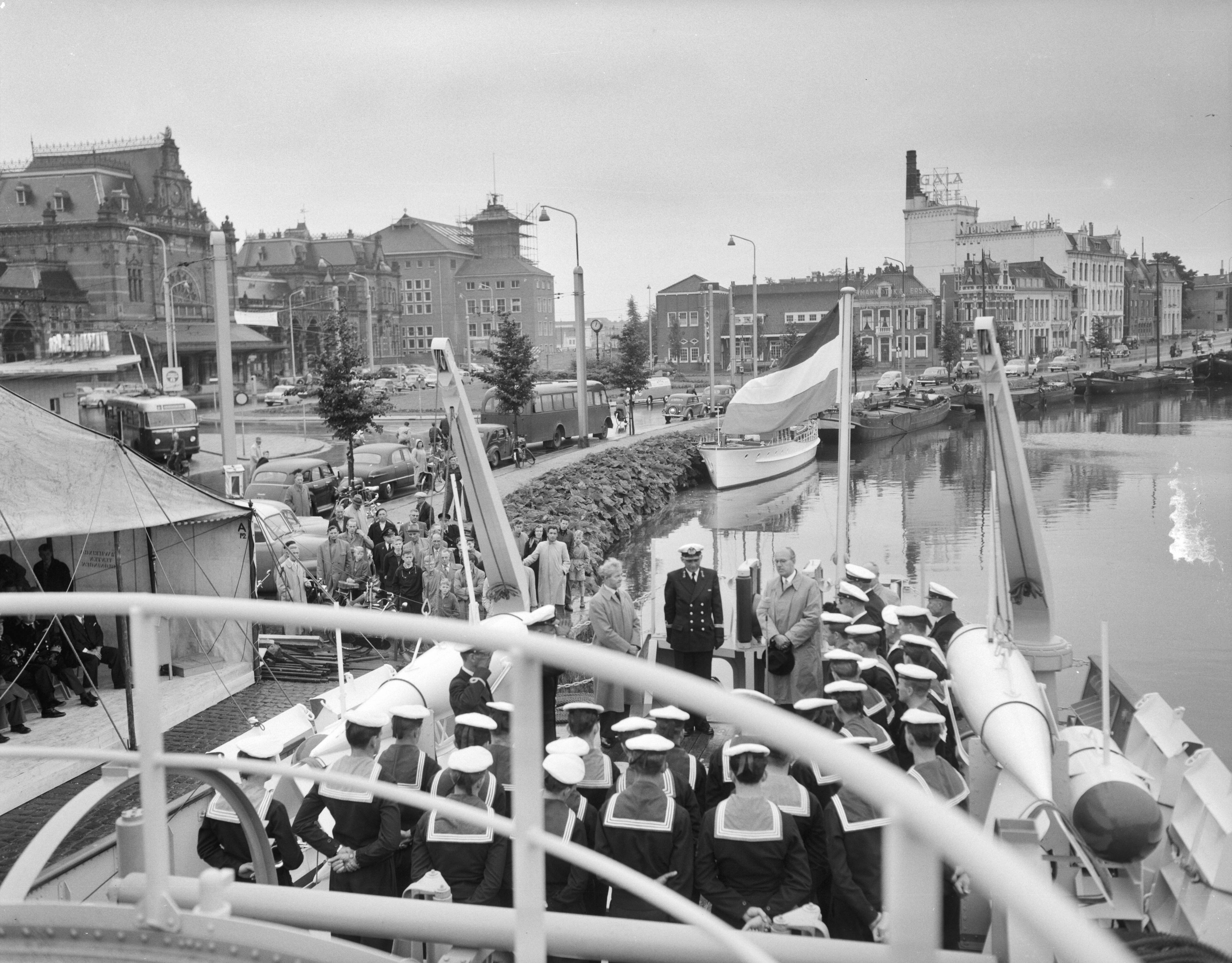 Overdracht en indienststelling van de kustmijnenveger Hr. Ms. "Lochem" in het Verbindingskanaal te Groningen — Overdracht en indienststelling van de kustmijnenveger Hr. Ms. "Lochem" in het Verbindingskanaal te Groningen. Toespraak op het achterdek door de burgemeester van Lochem, H.A. Beusekamp. In het midden de commandant, luitenant-ter-zee 2e klasse D. Lindner — Foto: Behrens, Herbert F. / Anefo. Licentie: Set B: Rechtenvrij / Publiek Domein. Bron: Nationaal Archief. http://hdl.handle.net/10648/a94bb930-d0b4-102d-bcf8-003048976d84