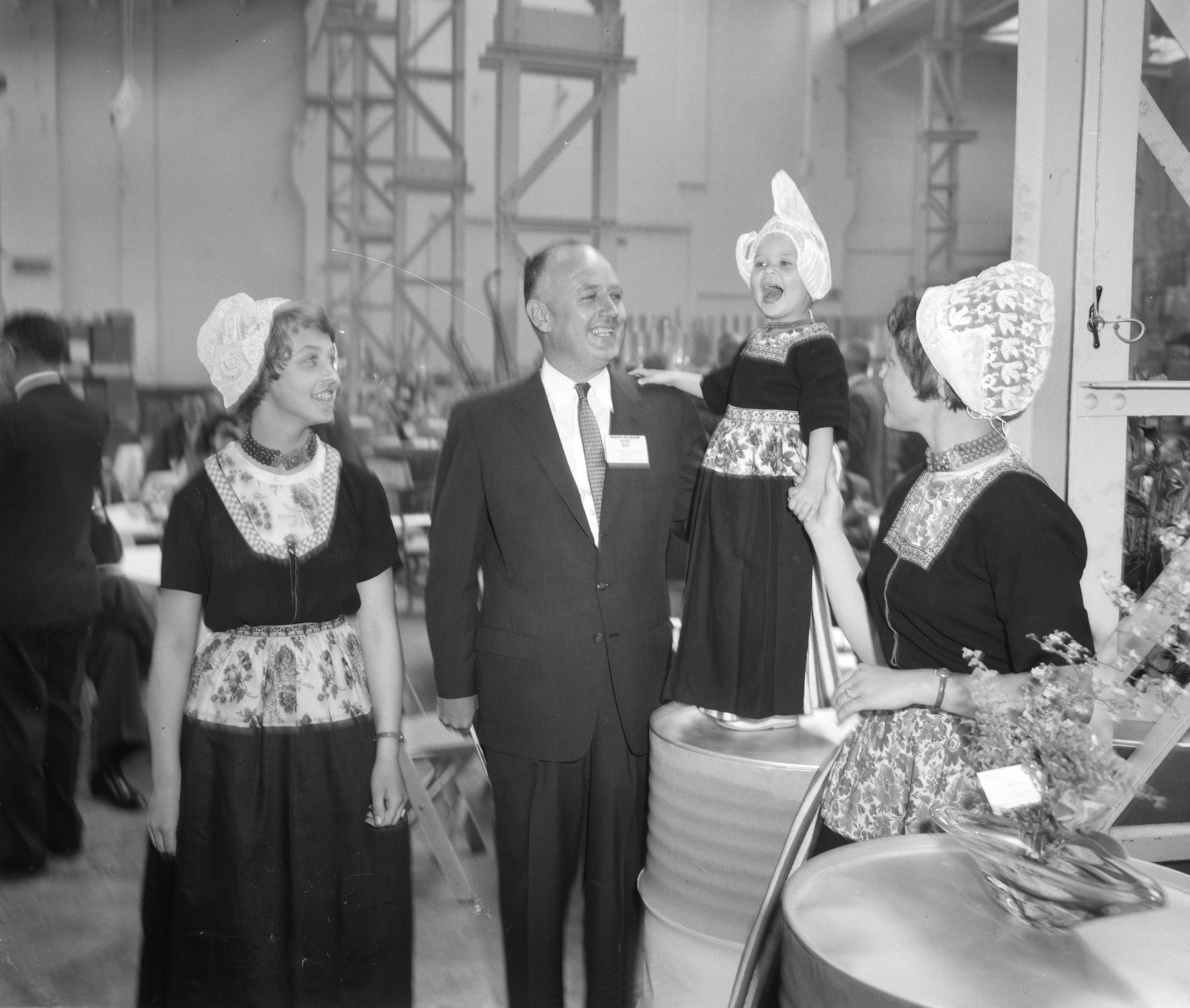 Fotocollectie Anefo — Opening fabriek Rust-Oleum te Haarlem. President-directeur Robert Fergusson jr., zoon van de oprichter, poseert met vrouwen en kind in klederdracht — Foto: Behrens, Herbert F. / Anefo. Licentie: Set B: Rechtenvrij / Publiek Domein. Bron: Nationaal Archief. http://hdl.handle.net/10648/a9b226c0-d0b4-102d-bcf8-003048976d84