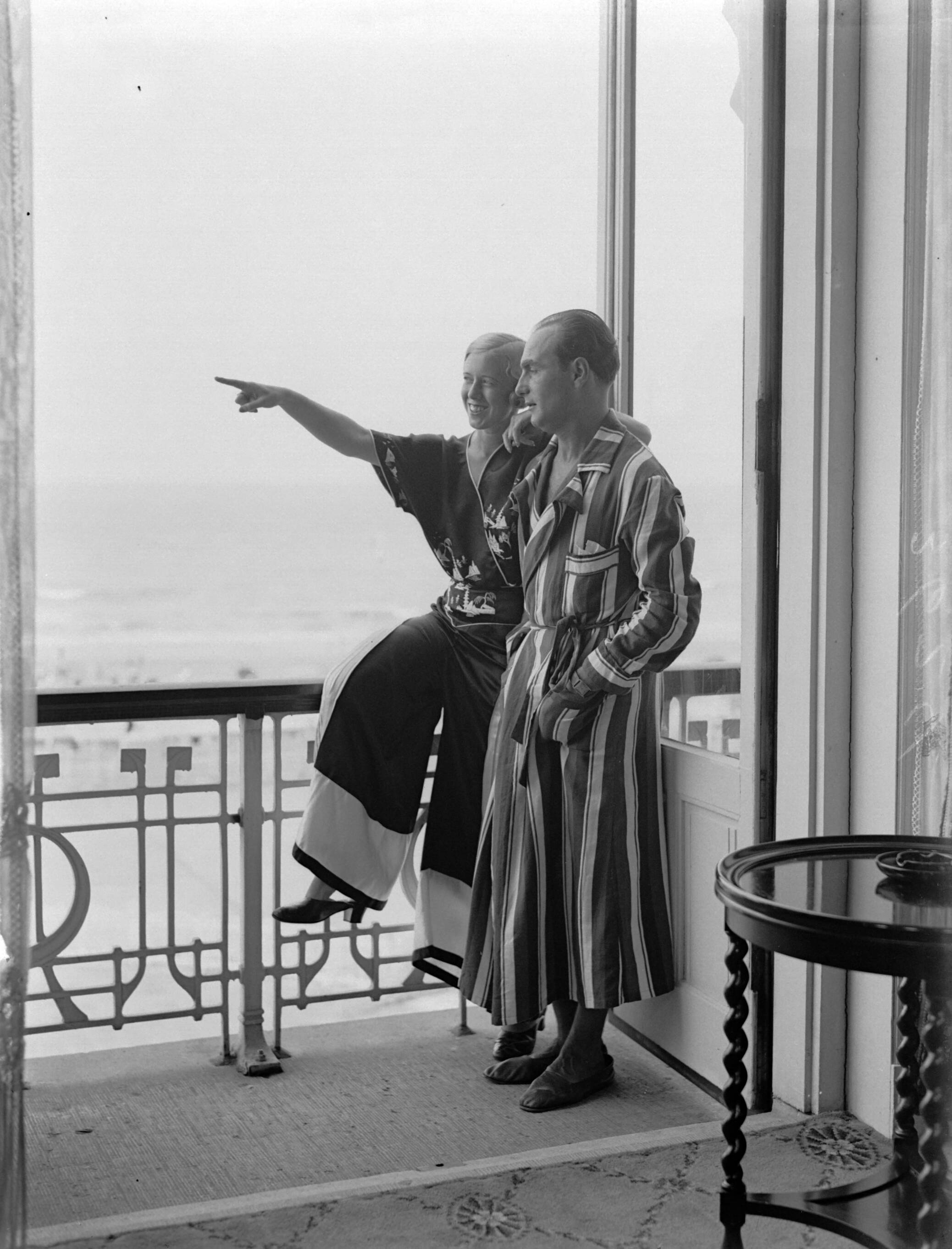 Scheveningen. — Een man (Farrar?) en een vrouw (Yvonne? bij het raam van een hotelkamer van het Palace Hotel in Scheveningen — Foto: Poll, Willem van de. Licentie: Set B: Rechtenvrij / Publiek Domein. Bron: Nationaal Archief. http://hdl.handle.net/10648/ae9ab602-d0b4-102d-bcf8-003048976d84