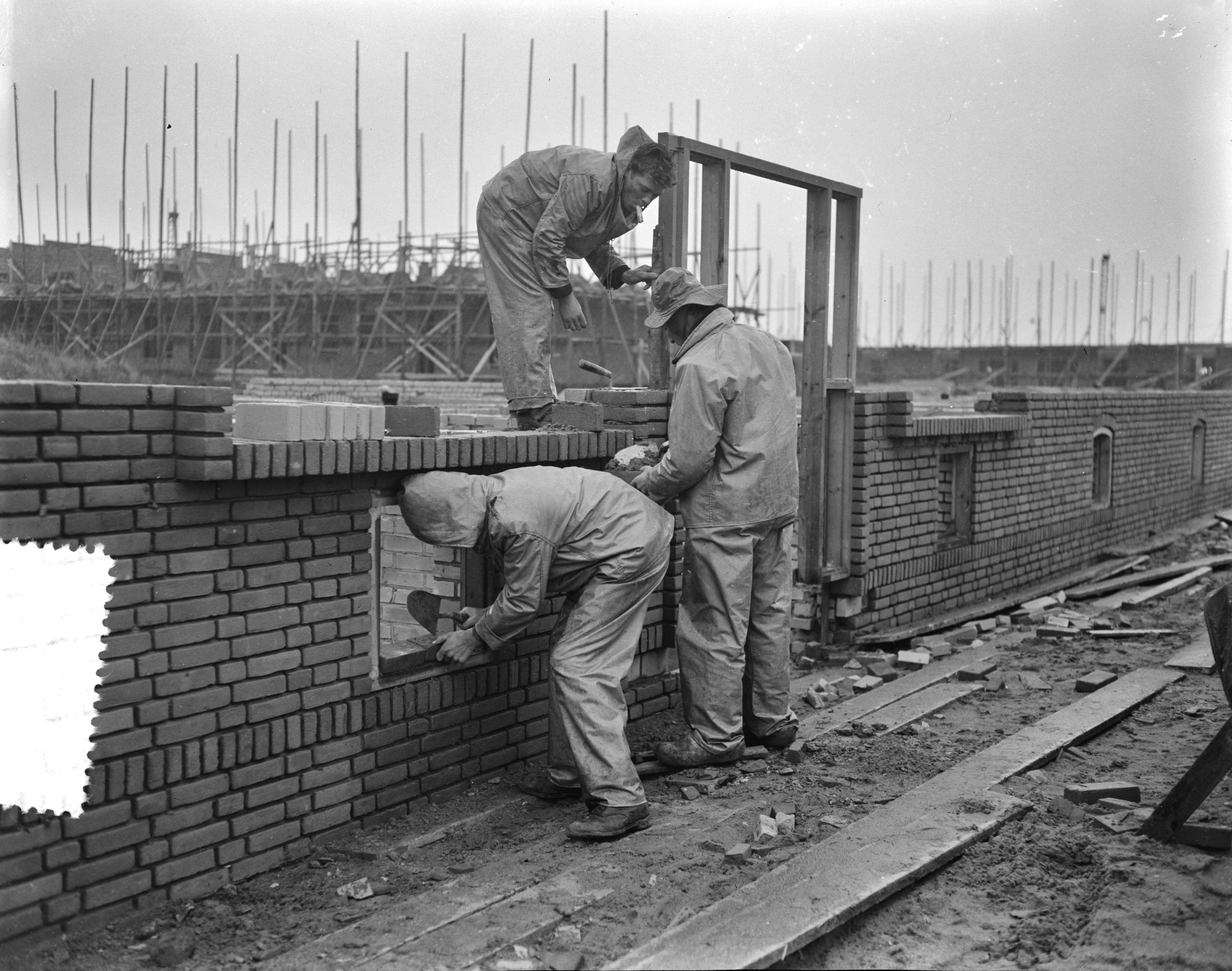Fotocollectie Anefo — Versnelling woningbouw in de winter (Rijswijk), kleding van de overheid voor de bouwvakarbeiders — Foto: Pot, Harry / Anefo. Licentie: Set B: Rechtenvrij / Publiek Domein. Bron: Nationaal Archief. http://hdl.handle.net/10648/a940b008-d0b4-102d-bcf8-003048976d84