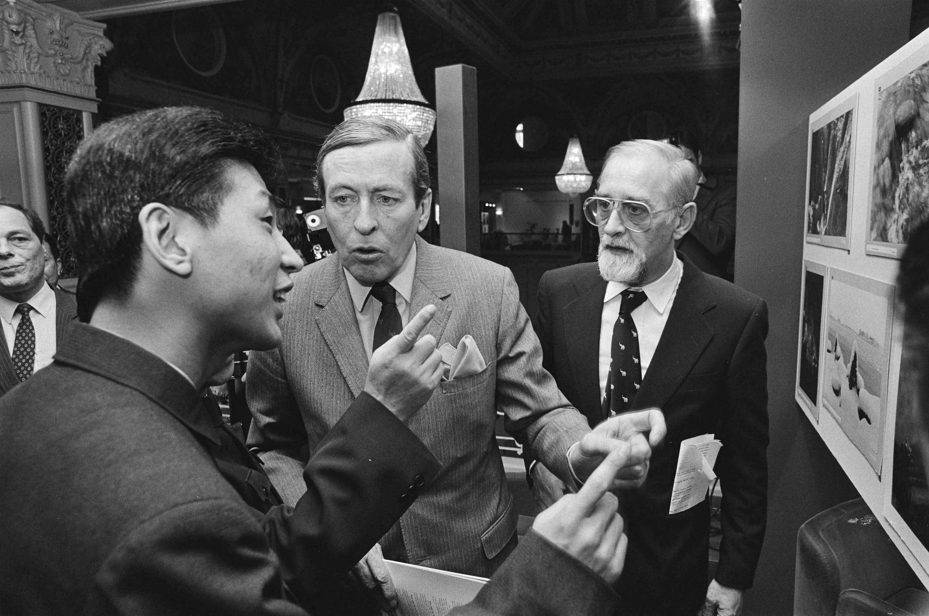Fotocollectie Anefo — Prins Claus woonde opening van fototentoonstelling "China Nu" in het Kurhaus te Scheveningen bij. Claus bij enkele Chinesen — Foto: Antonisse, Marcel / Anefo. Licentie: Set B: Rechtenvrij / Publiek Domein. Bron: Nationaal Archief. http://hdl.handle.net/10648/ad0f9db6-d0b4-102d-bcf8-003048976d84