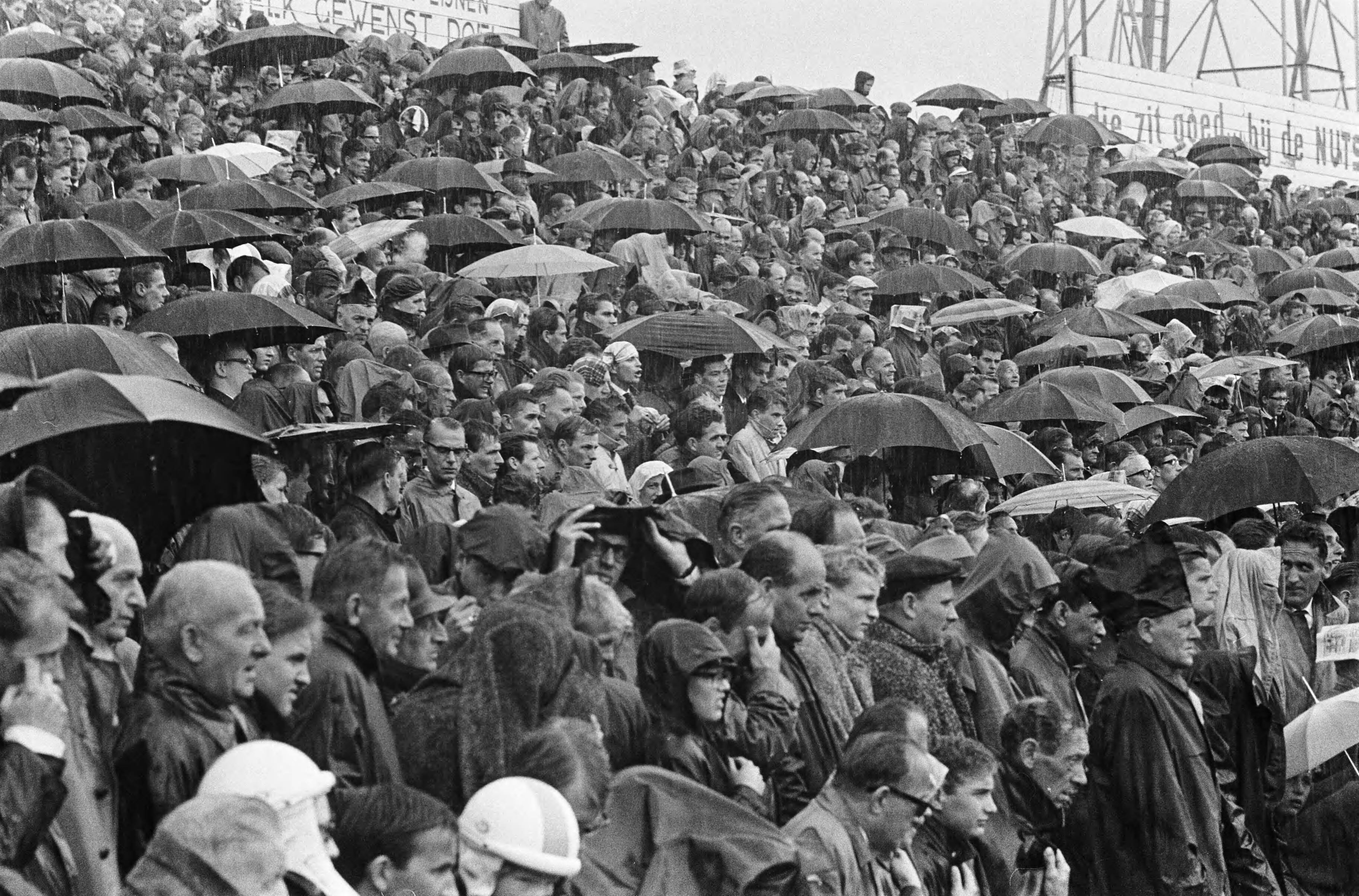 Fotocollectie Anefo — Voetbal. ADO tegen Sparta 2-2, publiek op de tribune in de regen — Foto: Kroon, Ron / Anefo. Licentie: Set B: Rechtenvrij / Publiek Domein. Bron: Nationaal Archief. http://hdl.handle.net/10648/aabc3e98-d0b4-102d-bcf8-003048976d84