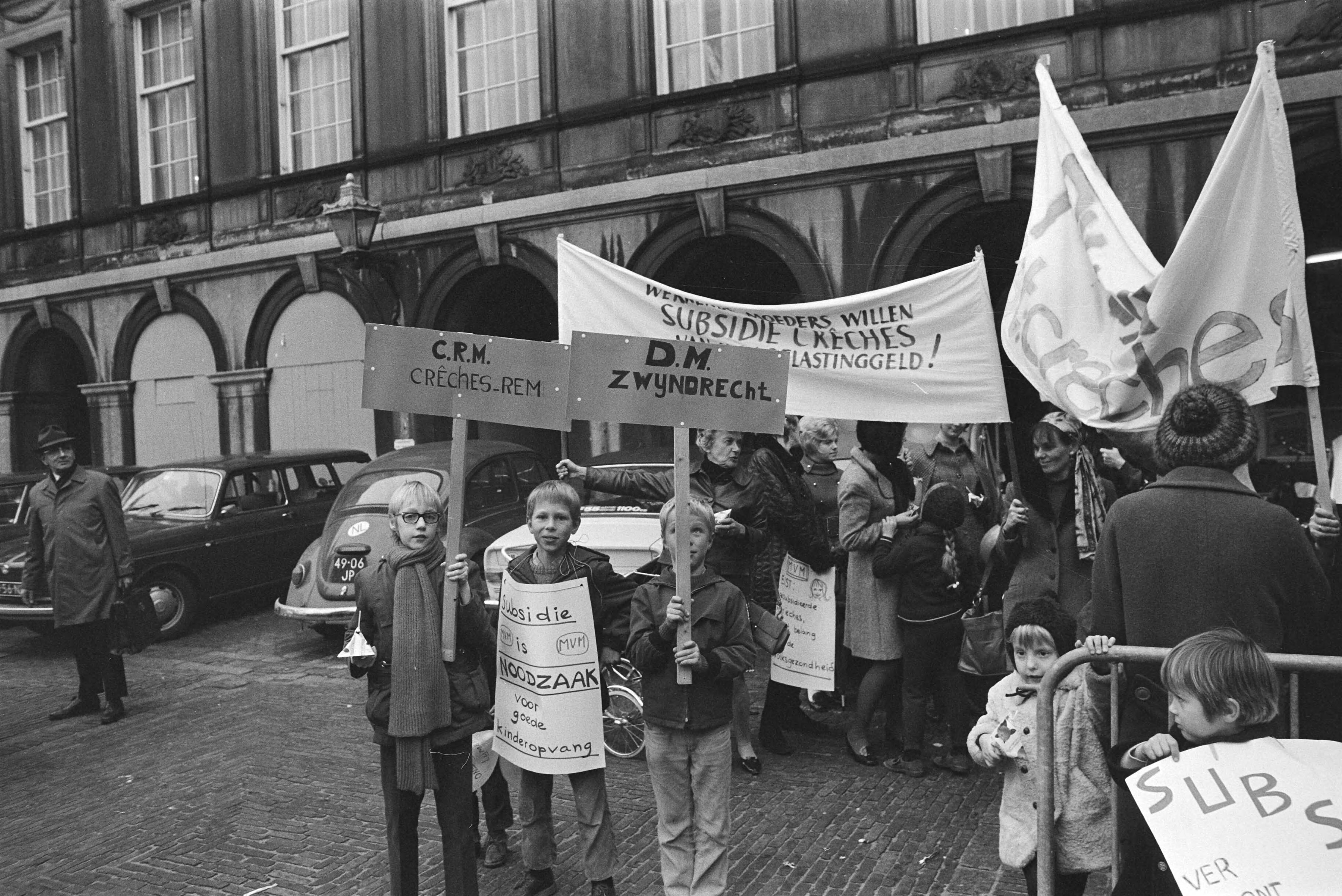 Fotocollectie Anefo — Demonstratie "Dolle Mina" tegen uitblijven creches op Binnenhof, Den Haag ; Dolle Minas met kinderen en borden op Binnenhof — Foto: Mieremet, Rob / Anefo. Licentie: Set B: Rechtenvrij / Publiek Domein. Bron: Nationaal Archief. http://hdl.handle.net/10648/abaa52fe-d0b4-102d-bcf8-003048976d84