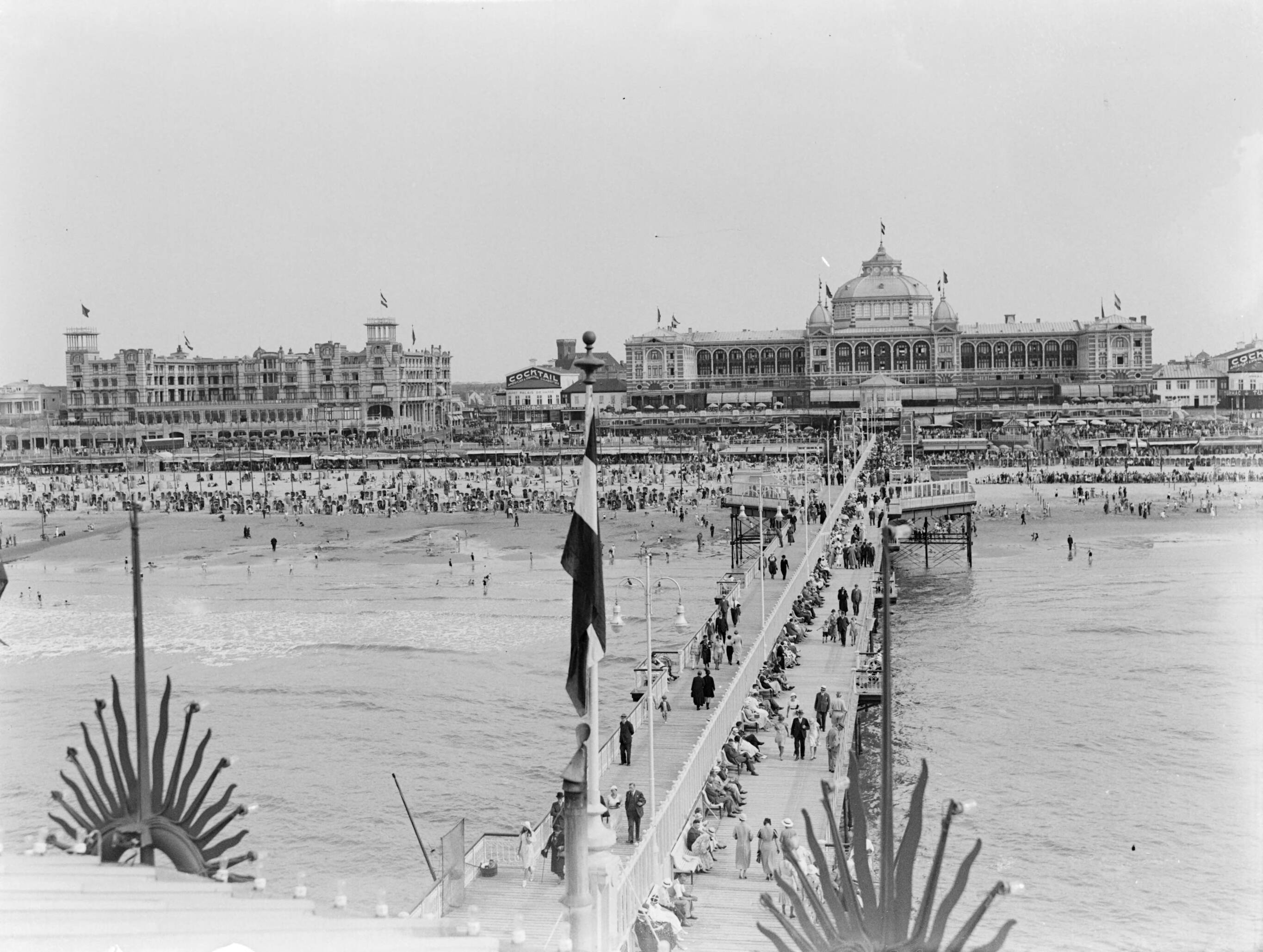Scheveningen. — De Pier in Scheveningen met op de achtergrond het Kurhaus — Foto: Poll, Willem van de. Licentie: Set B: Rechtenvrij / Publiek Domein. Bron: Nationaal Archief. http://hdl.handle.net/10648/ae9ac9e4-d0b4-102d-bcf8-003048976d84