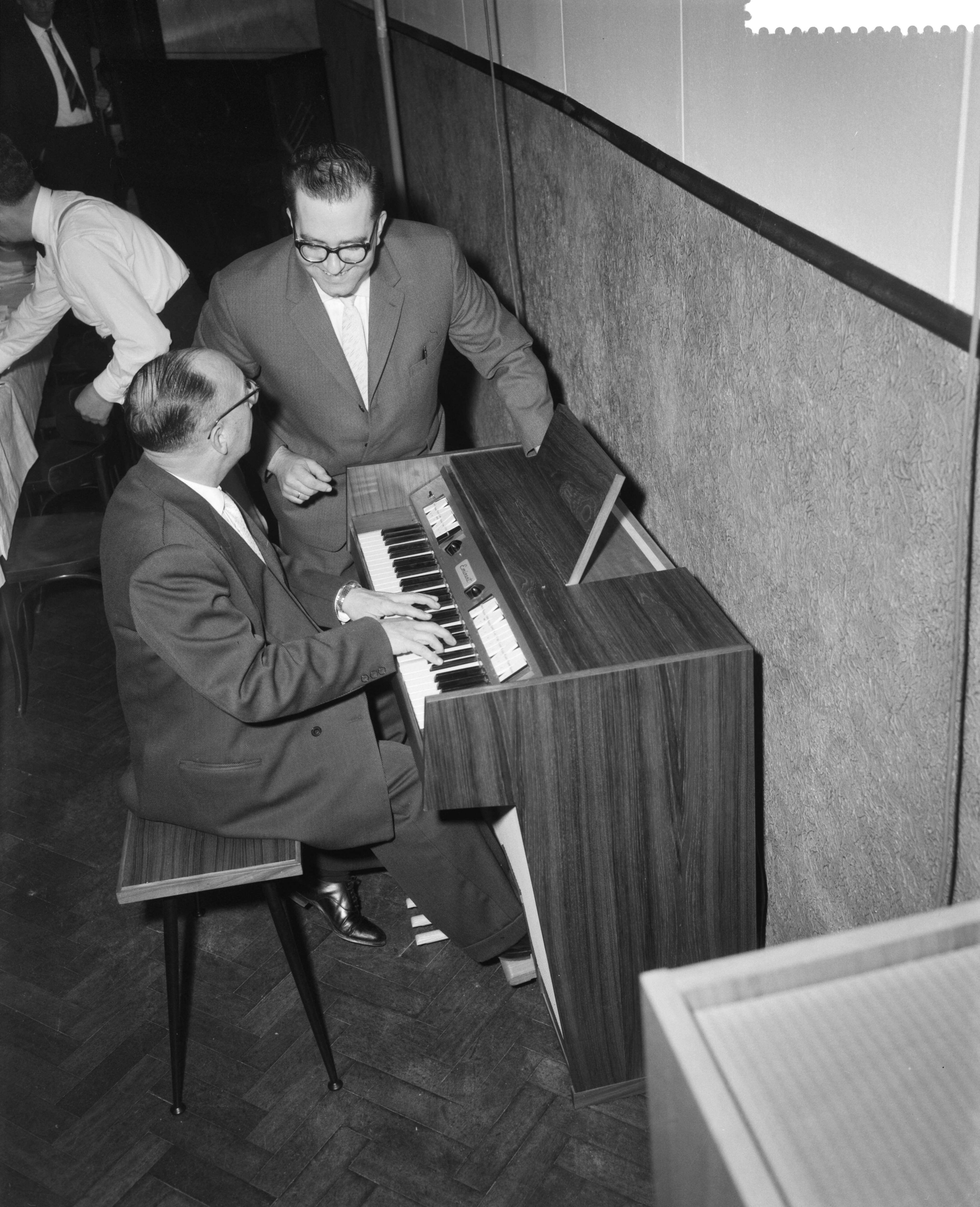 Fotocollectie Anefo — Demonstratie van nieuw elektronisch huisorgel te Bodegraven. Ontwerper Hans Versteegt geeft toelichting, terwijl Pierre Palla speelt — Foto: Behrens, Herbert F. / Anefo. Licentie: Set B: Rechtenvrij / Publiek Domein. Bron: Nationaal Archief. http://hdl.handle.net/10648/a9c10974-d0b4-102d-bcf8-003048976d84