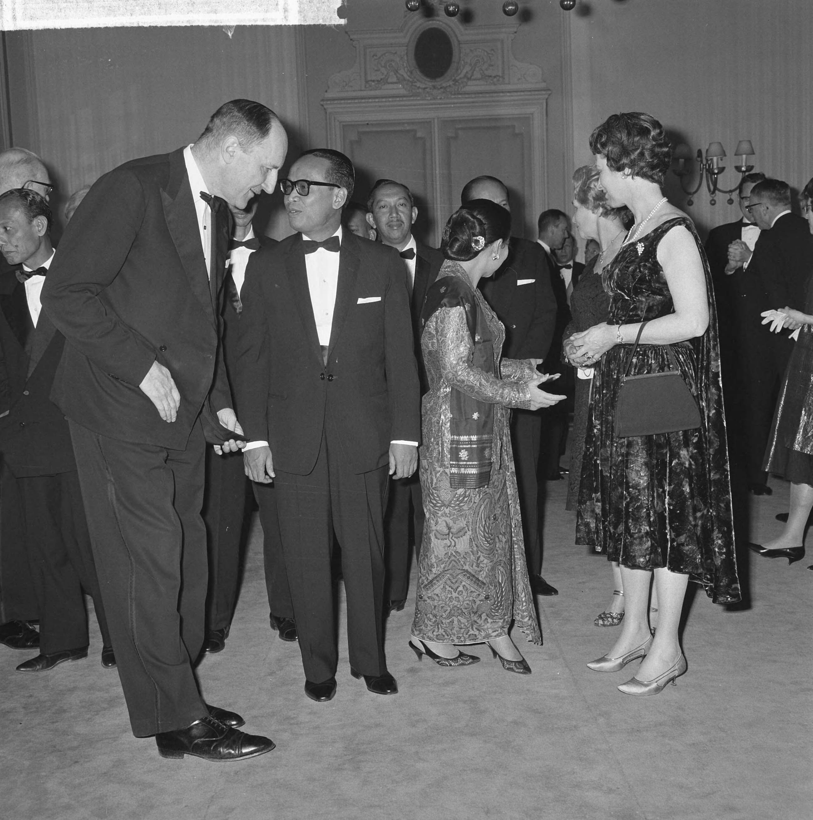 Fotocollectie Anefo — De Nederlandse regering heeft de Indonesische minister Soebandrio en zijn echtgenote een diner aangeboden in het Kurhaus te Scheveningen. Voor het aan tafel gaan, vlrnr. minister Luns , dr. Soebandrio, mverv Soebandrio, mevr. Jonkman (echtgenote van de voorzitter van de Eerste Kamer) en mevr. Luns — Foto: Pot, Harry / Anefo. Licentie: Set B: Rechtenvrij / Publiek Domein. Bron: Nationaal Archief. http://hdl.handle.net/10648/aa627e8a-d0b4-102d-bcf8-003048976d84