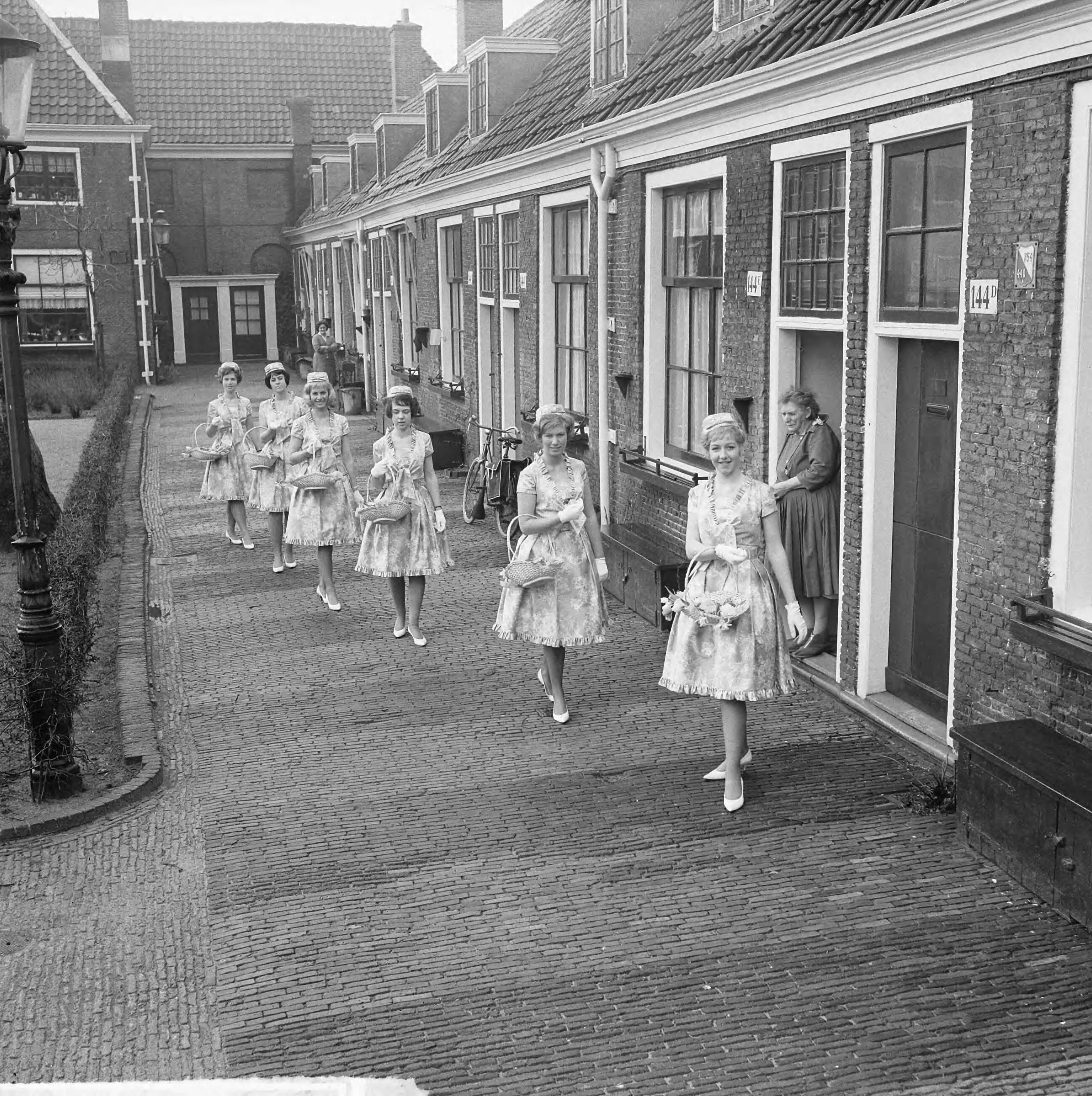 Fotocollectie Anefo — Haarlemse bloemenmeisjes in nieuw pakje, hun nieuwe Boussac katoenen jurkjes. Enkele meisjes op het Proveniershofje te Haarlem — Foto: Nijs, Jac. de / Anefo. Licentie: Set B: Rechtenvrij / Publiek Domein. Bron: Nationaal Archief. http://hdl.handle.net/10648/aa2e6bd6-d0b4-102d-bcf8-003048976d84