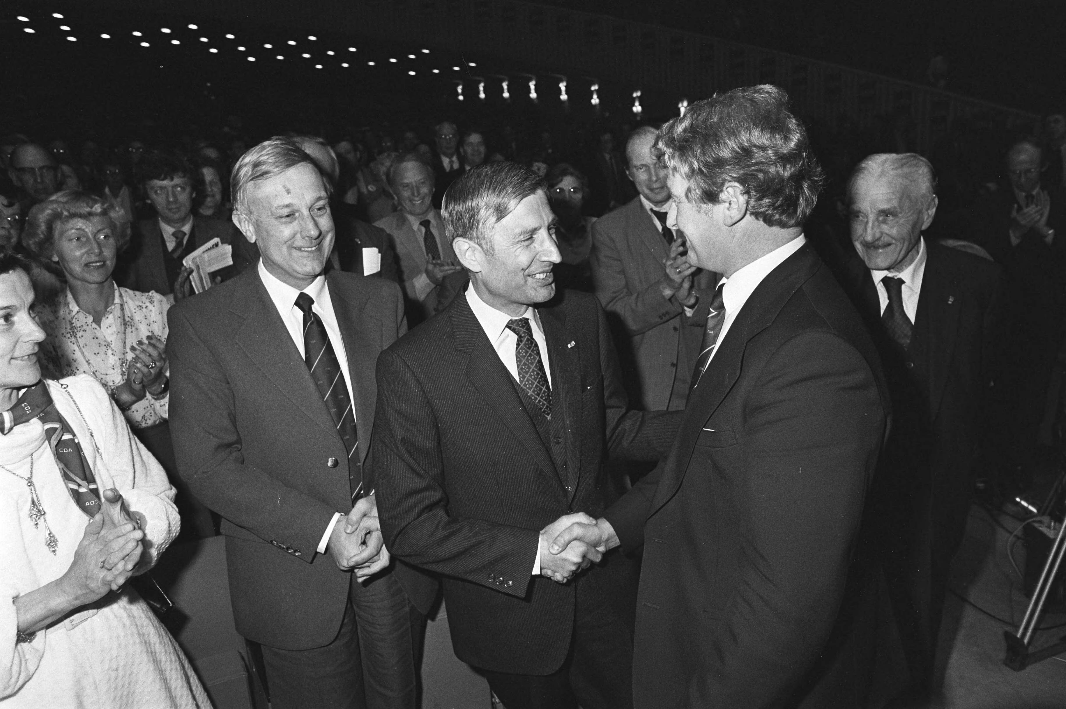 Fotocollectie Anefo — Fusie congres CDA in Den Haag , Van Agt feliciteerd nieuwe voorzitter CDA Bukman, links scheidend voorzitter Steenkamp — Foto: Antonisse, Marcel / Anefo. Licentie: Set B: Rechtenvrij / Publiek Domein. Bron: Nationaal Archief. http://hdl.handle.net/10648/acea8d1e-d0b4-102d-bcf8-003048976d84