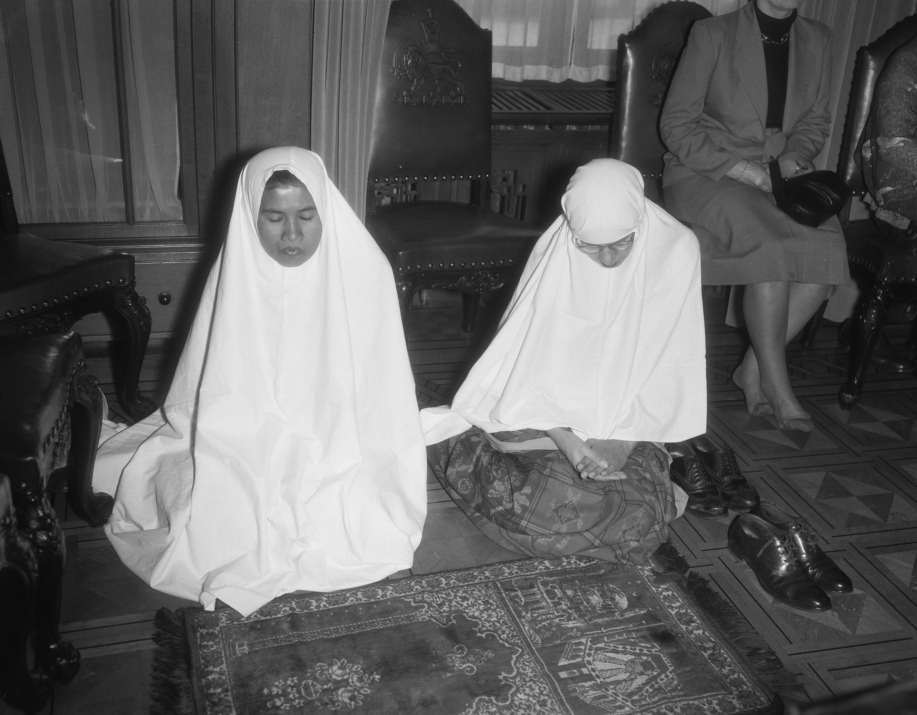 Fotocollectie Anefo — Viering in Wassenaar van de islamitische feestdag Idul Adha [Eidh al-Adha]. Twee biddende vrouwen — Foto: Duinen, G.W. van / Anefo. Licentie: Set B: Rechtenvrij / Publiek Domein. Bron: Nationaal Archief. http://hdl.handle.net/10648/a9279582-d0b4-102d-bcf8-003048976d84