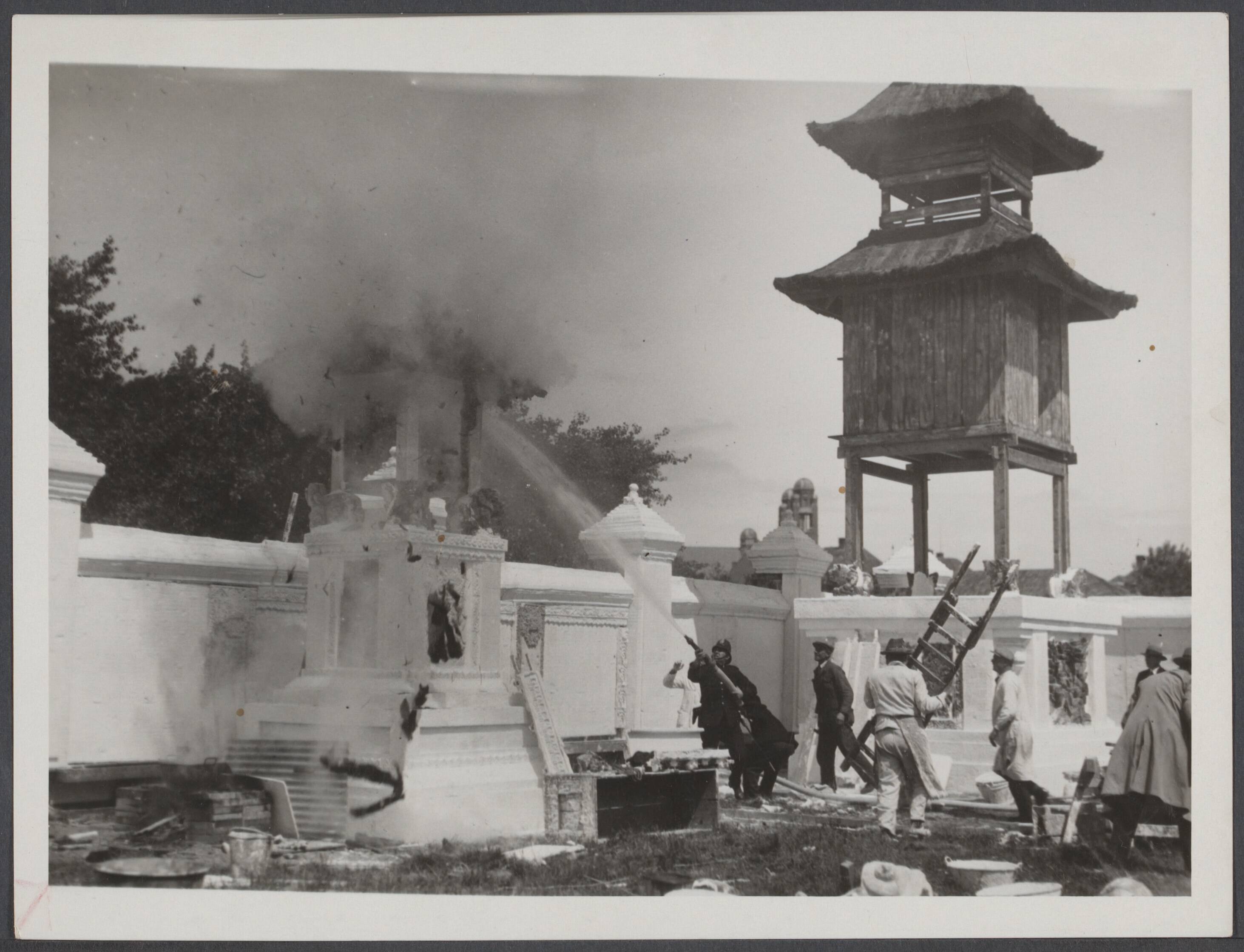 Koloniale tentoonstellingen, Den Haag 1932 - Nederland — Er is in de ochtend brand uitgebroken in een der bijgebouwtjes der Indische Tentoonstelling te Den Haag. De brandweer in actie — Foto: N.V. Vereenigde Fotobureaux. Licentie: Set B: Rechtenvrij / Publiek Domein. Bron: Nationaal Archief. http://hdl.handle.net/10648/98c838d3-192f-4219-878e-fe5fdd6ea402