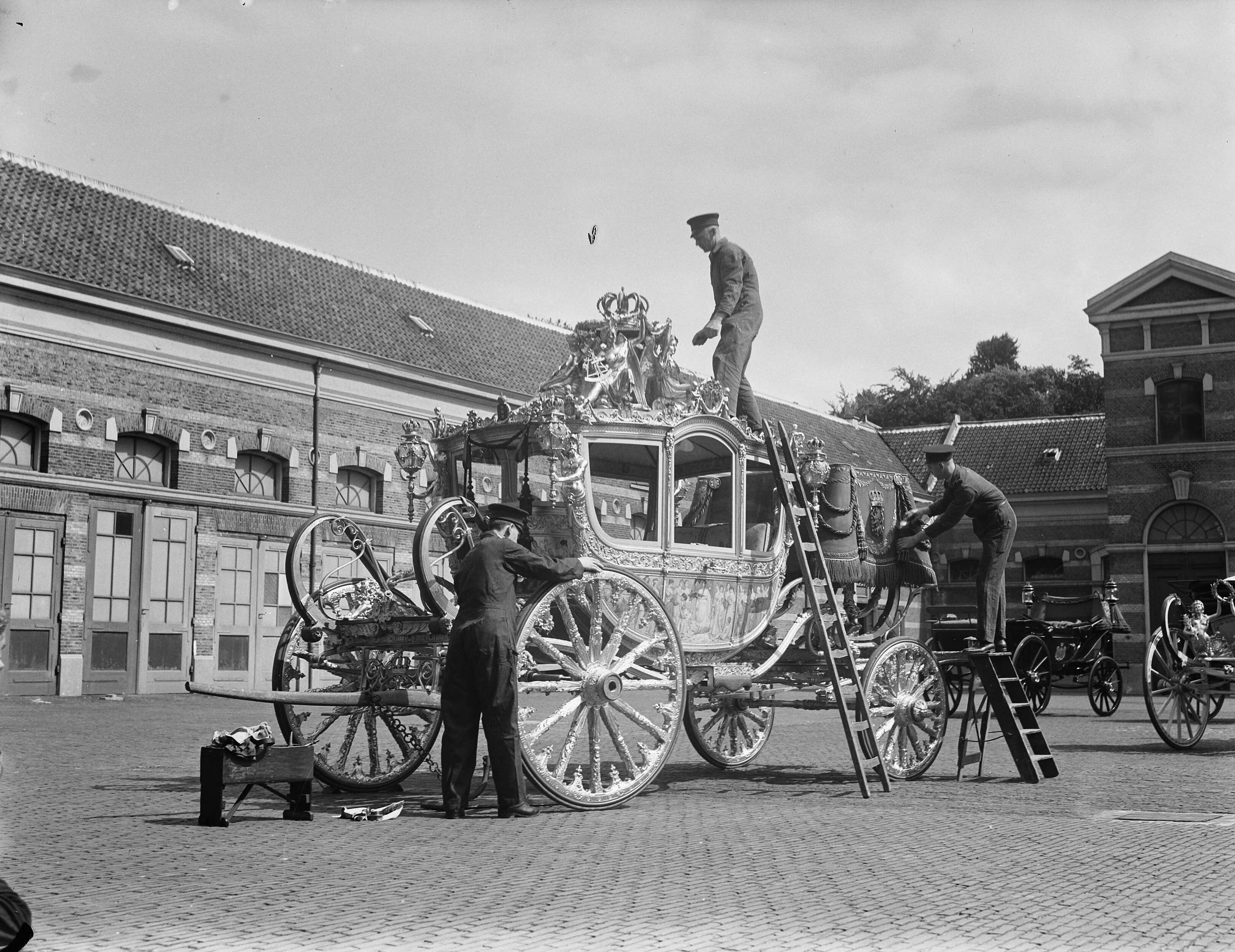 Koninklijke Stallen te Den Haag. Voorbereidingen viering Regeringsjubileum — Koninklijks Stallen te Den Haag. Gouden Koets wordt schoongemaakt — Foto: Merk, Ben / Anefo. Licentie: Set B: Rechtenvrij / Publiek Domein. Bron: Nationaal Archief. http://hdl.handle.net/10648/a8babaac-d0b4-102d-bcf8-003048976d84