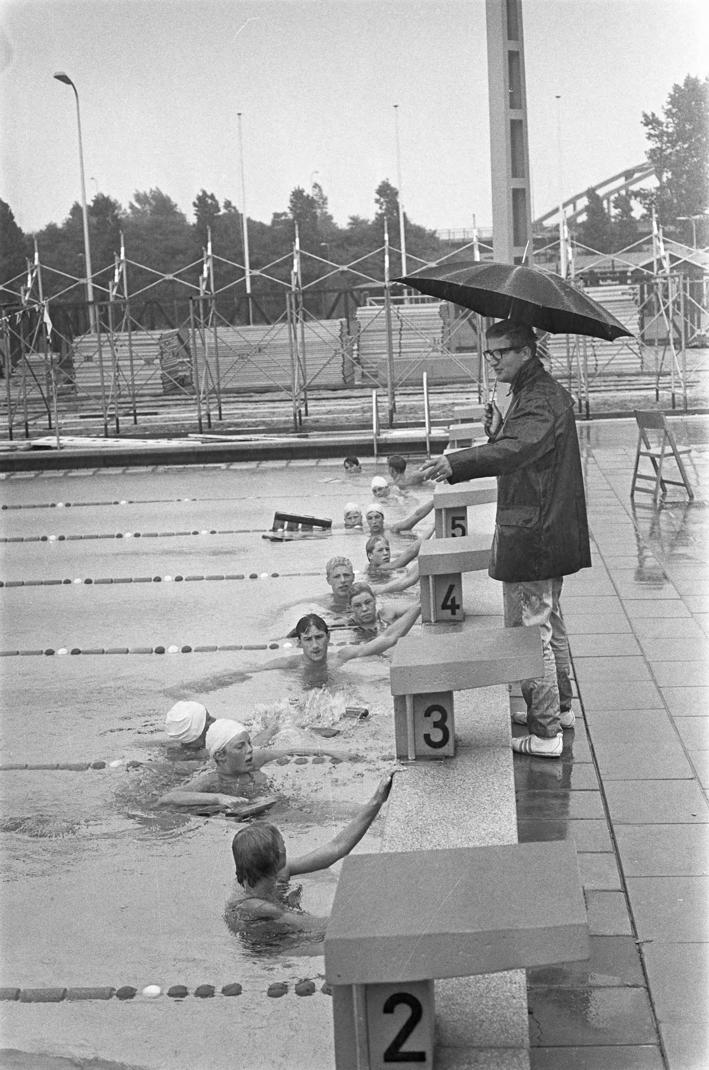 Fotocollectie Anefo — Europese Kampioenschappen zwemmen, Rob Kerkhoven neemt zwemmers onder handen — Foto: Kroon, Ron / Anefo. Licentie: Set B: Rechtenvrij / Publiek Domein. Bron: Nationaal Archief. http://hdl.handle.net/10648/aaf54ec2-d0b4-102d-bcf8-003048976d84