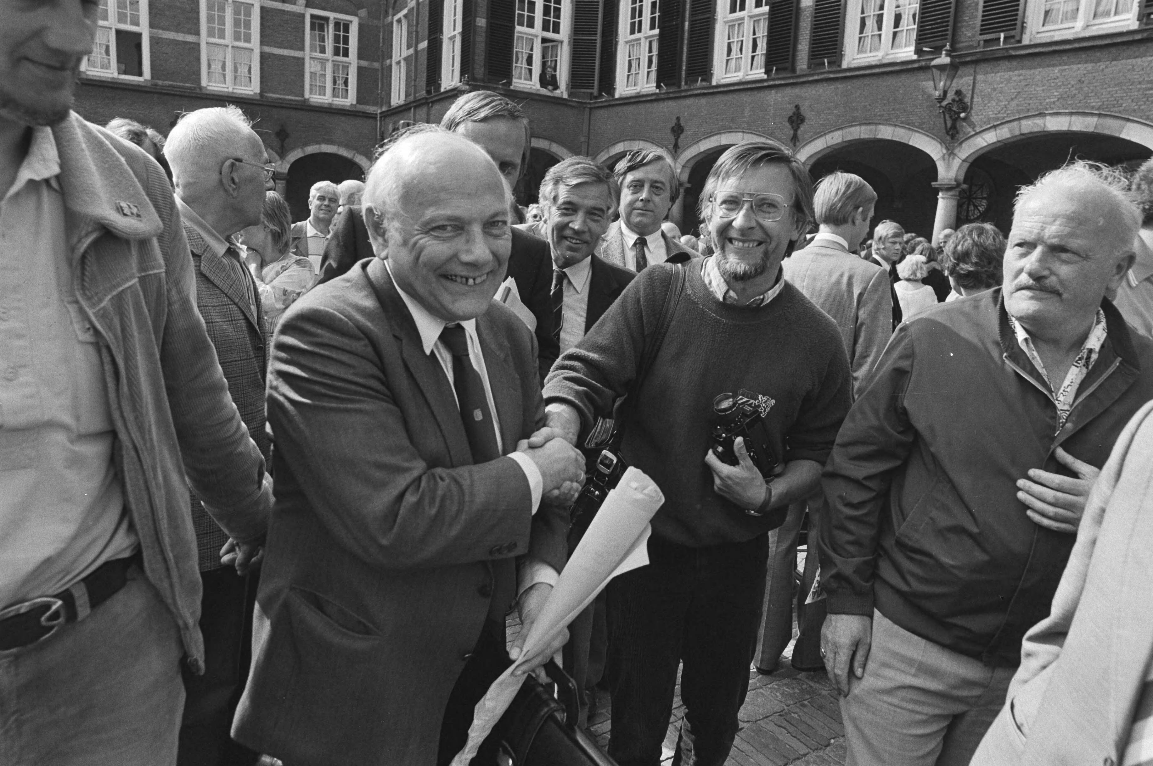 Kabinetsformatie 1981 — Een vrolijke PvdA fractievoorzitter Joop den Uyl tussen het publiek op het Binnenhof in den Haag tijdens de kabinetsformatie van 1981 — Foto: Antonisse, Marcel / Anefo. Licentie: Set B: Rechtenvrij / Publiek Domein. Bron: Nationaal Archief. http://hdl.handle.net/10648/ad02acb4-d0b4-102d-bcf8-003048976d84