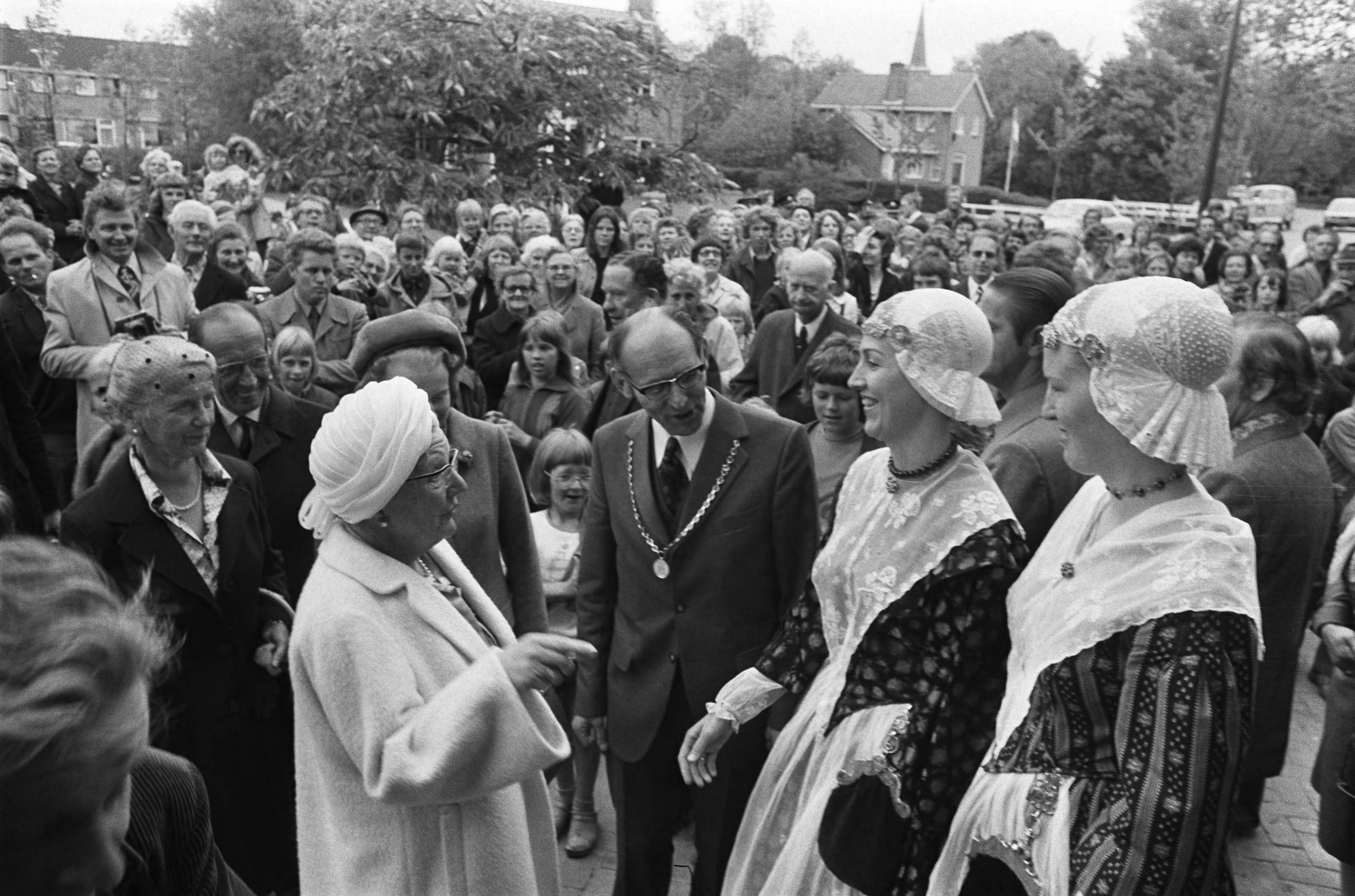 Bezoek van koningin Juliana aan Friesland — Vrouwen in klederdracht begroeten koningin Juliana in Mantgum; in het midden burgemeester Kuiper — Foto: Verhoeff, Bert / Anefo. Licentie: Set B: Rechtenvrij / Publiek Domein. Bron: Nationaal Archief. http://hdl.handle.net/10648/ac69d322-d0b4-102d-bcf8-003048976d84